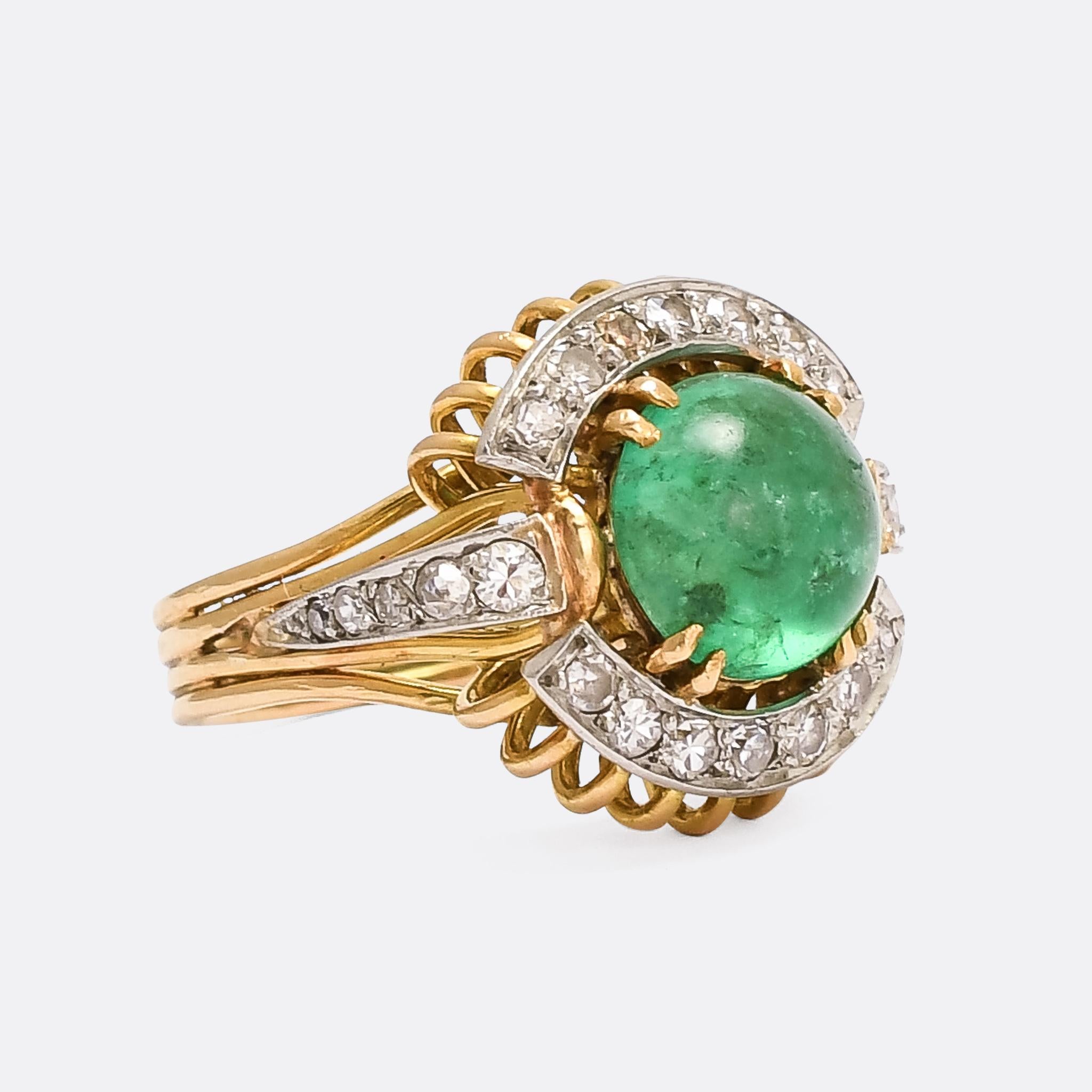 A striking 1960s cocktail ring set with a central cabochon emerald and a cluster of bright eight-cut diamonds. It's crafted in 18 karat gold with millegrain platinum settings and an unusual gold wirework gallery. French import marks indicate that it