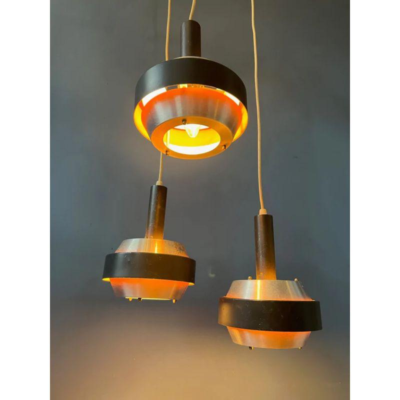 Classic Lakro cascade consisting of three aluminium shades. The orange insides produce a warm reflection of light. The lamp requires three small E27 (standard) lightbulbs.

Dimensions:
ø Shades: 17 cm
Heigh shades: 19 cm
Height (adjustable): 125