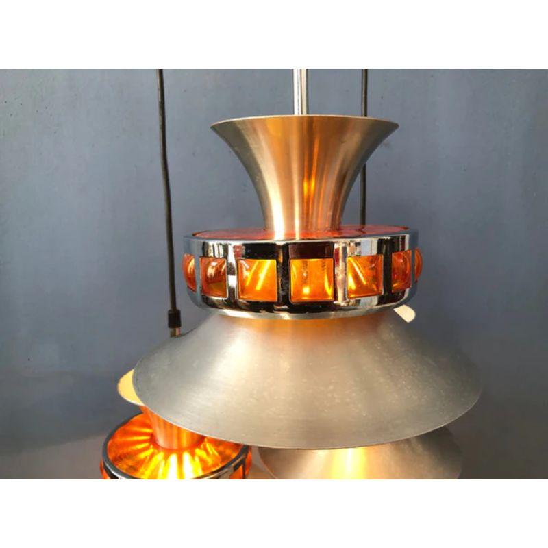 Beautiful space age cascade by the dutch company Lakro Amstelveen. The lamp consists of three chrome shades with orange acryllic diamonds, producing a nice light effect. The three lamps come together in the ceiling mount. The lamp requires three