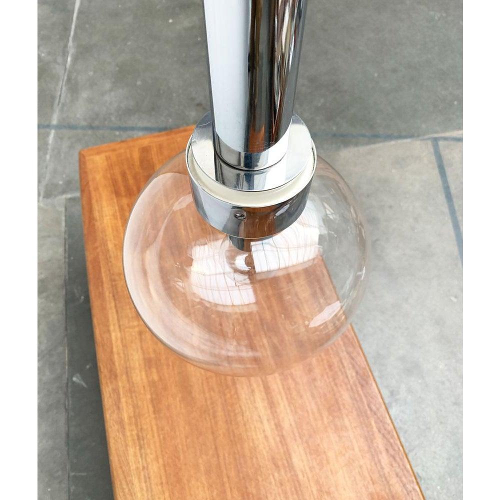 Pendant lamp from the well-known manufacturer staff based on a design by motoko ishii from the 70s.

Simple design language with fancy materiality. A long chrome cylinder at the end of which sits a large glass sphere. A special element is the large