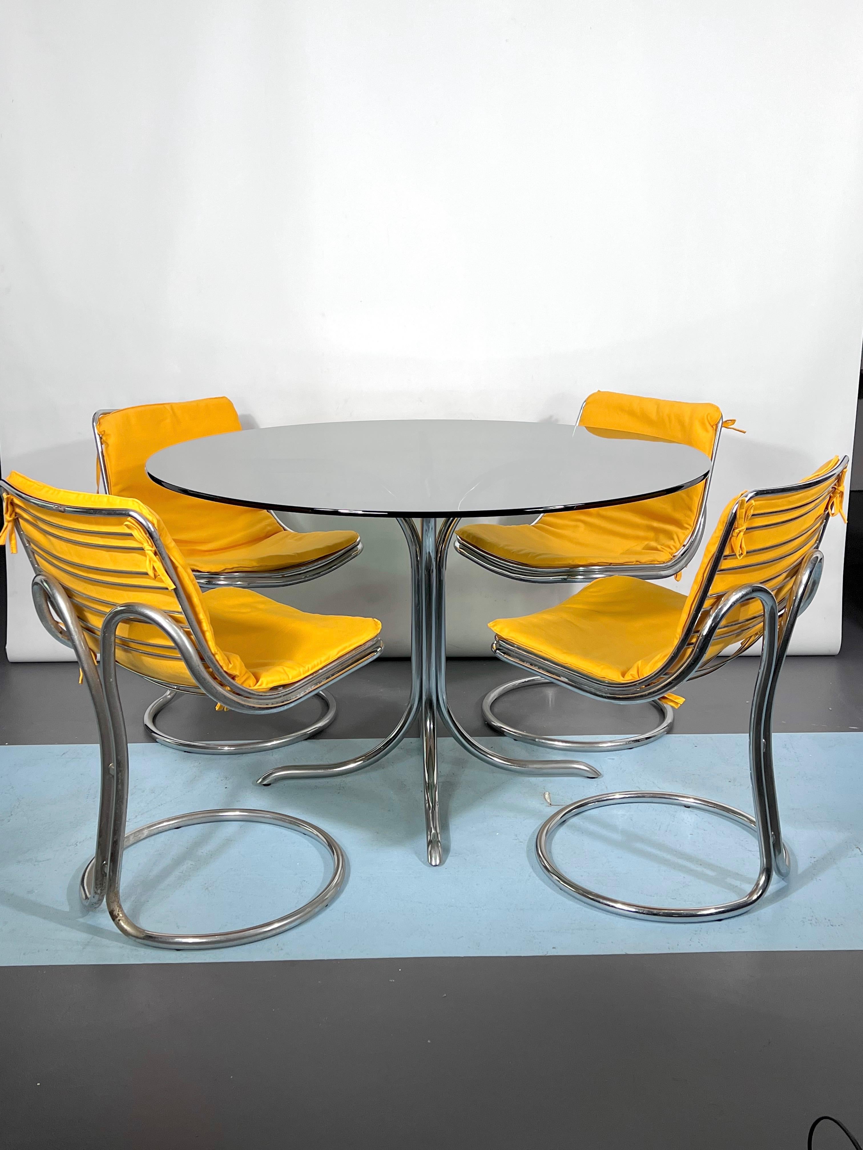 Very good original vintage condition with trace of age and use and small oxidation on the chrome for this set of a dinner table plus four chairs. Reminiscent of the style of Gastone Rinaldi for Rima, they’re made from chrome. The round fumè glass