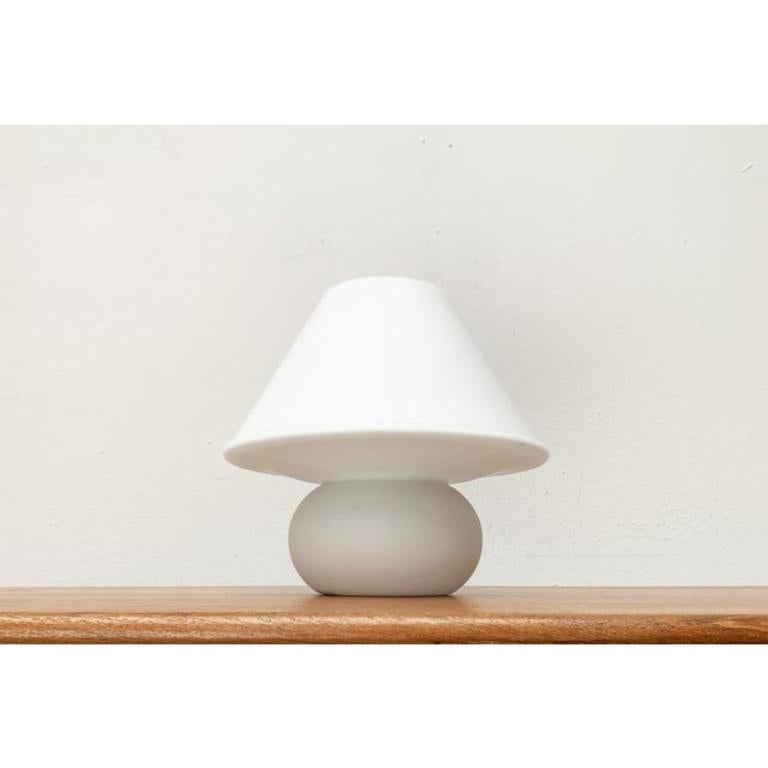 Imposante lampe de table en verre de la célèbre maison Glashütte Limburg.

La lampe présente la forme classique d'une lampe de table avec un parapluie et un pied. Cependant, cette lampe est faite de verre dans un morceau de verre et la forme semble