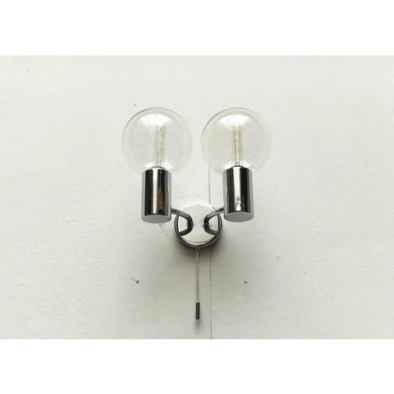 Mid century wall lamp from staff according to a design by the japanese designer motoko ishii.

a special element are the screwable glass balls that protect the lamp and optically enlarge it. The actually small e14 lamp gets the appearance of a globe