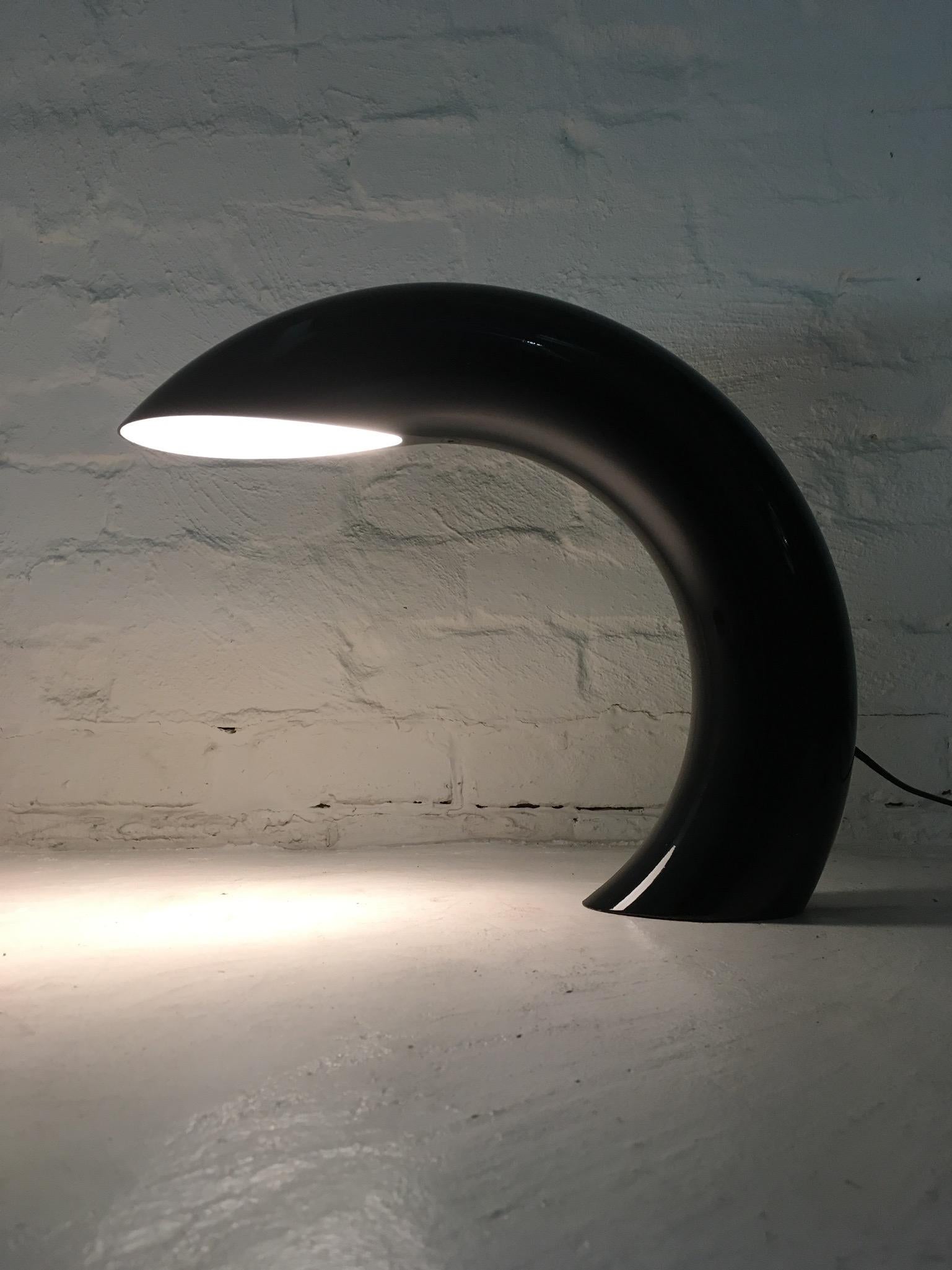 This 1970s Space Age Italian tubular metal desk lamp is manufactured from a single piece of extruded metal (except the internal bulb holder, which is a removable part). It has real presence. It's elegant and mysterious. It's also practical and