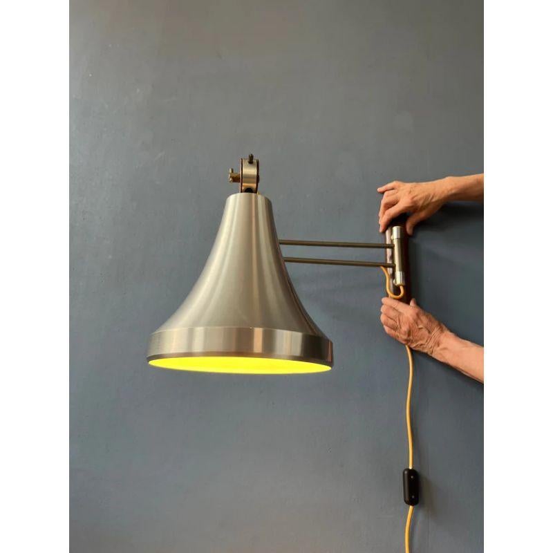 Rare Lakro swing-arm wall lamp with an aluminium shade. The shade can be fixated in different ways and the swing-arm can be adjusted. The lamp requires an E27 (standard) lightbulb and currently has an EU-plug.

Dimensions:
ø Shades: 19