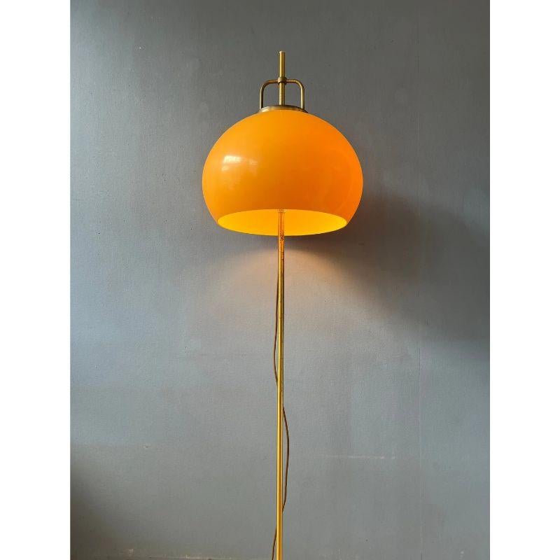 A space age classic: the Guzzini Lucerna floor lamp with large mushroom shade in yellow (slightly orange, but more yellow) colour. The shade can be moved up and down the base. The lamp requires two E27 lightbulbs and currently has an