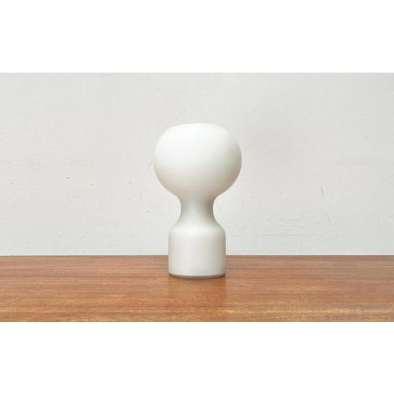 Glass table lamp from Philips based on a design by Jean-Paul Edmonds-Alt from the 70s.

A table lamp with a simple shape and color. The lamp body is made entirely of glass with a white overlay. The elegant shape of this light object has an effect