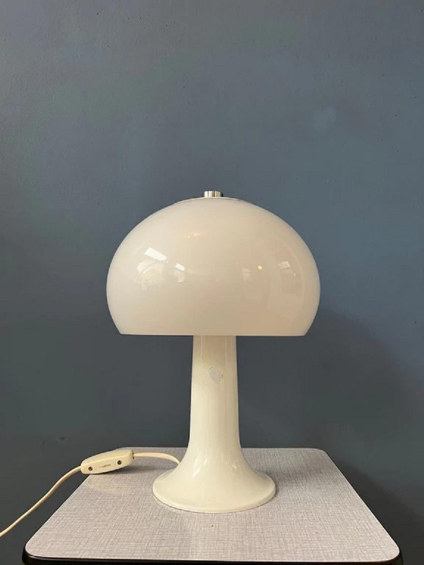 Eine niedliche klassische Pilz-Tischlampe der niederländischen Marke Herda in weiß/beige. Der edle weiße Pilzschirm erzeugt ein schönes, warmes Licht. Die Lampe benötigt eine E27-Glühbirne (Standard) und hat derzeit einen EU-Stecker.

Abmessungen:
ø