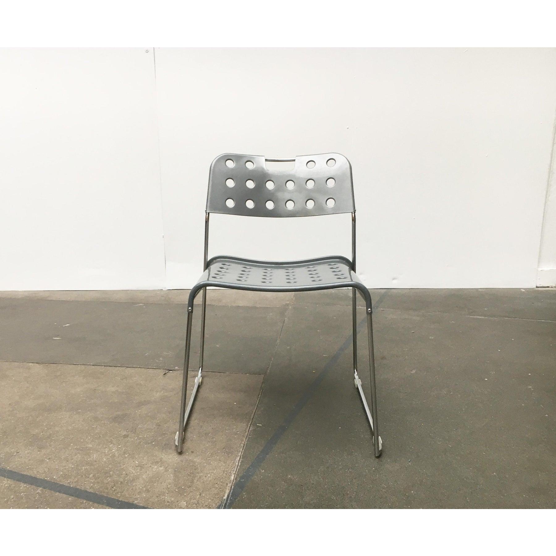 Chaise empilable du fabricant italien Bieffeplast, conçue par Rodney Kinsman dans les années 70.

La chaise est constituée d'un cadre chromé finement exécuté avec une assise et un dossier en tôle d'acier peinte. Le détail le plus frappant est la