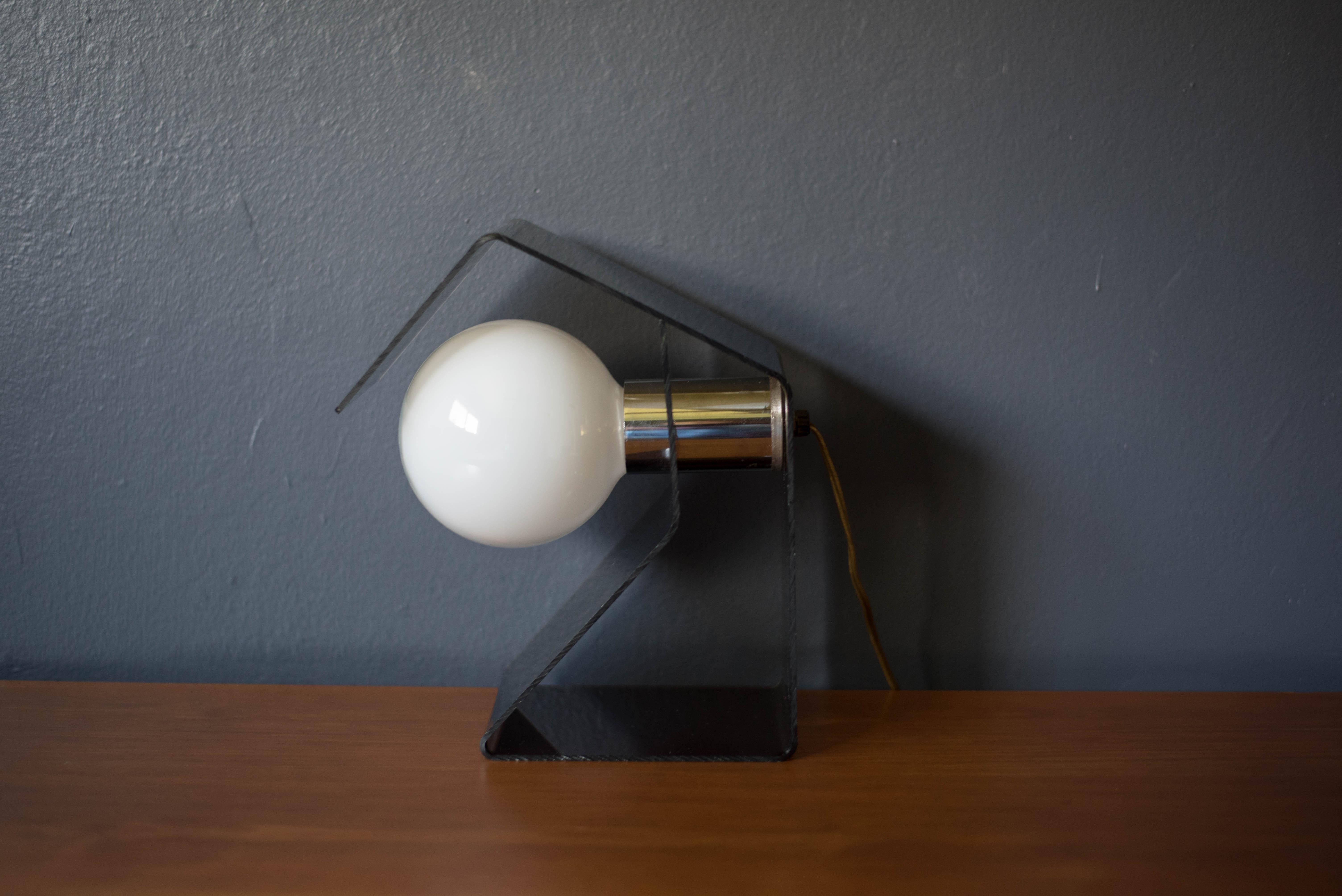 Mid-Century Modern accent globe table lamp, circa 1970s. This piece displays an angular smoked acrylic frame and chrome accents. Globe light bulb not included.


Offered by Mid Century Maddist