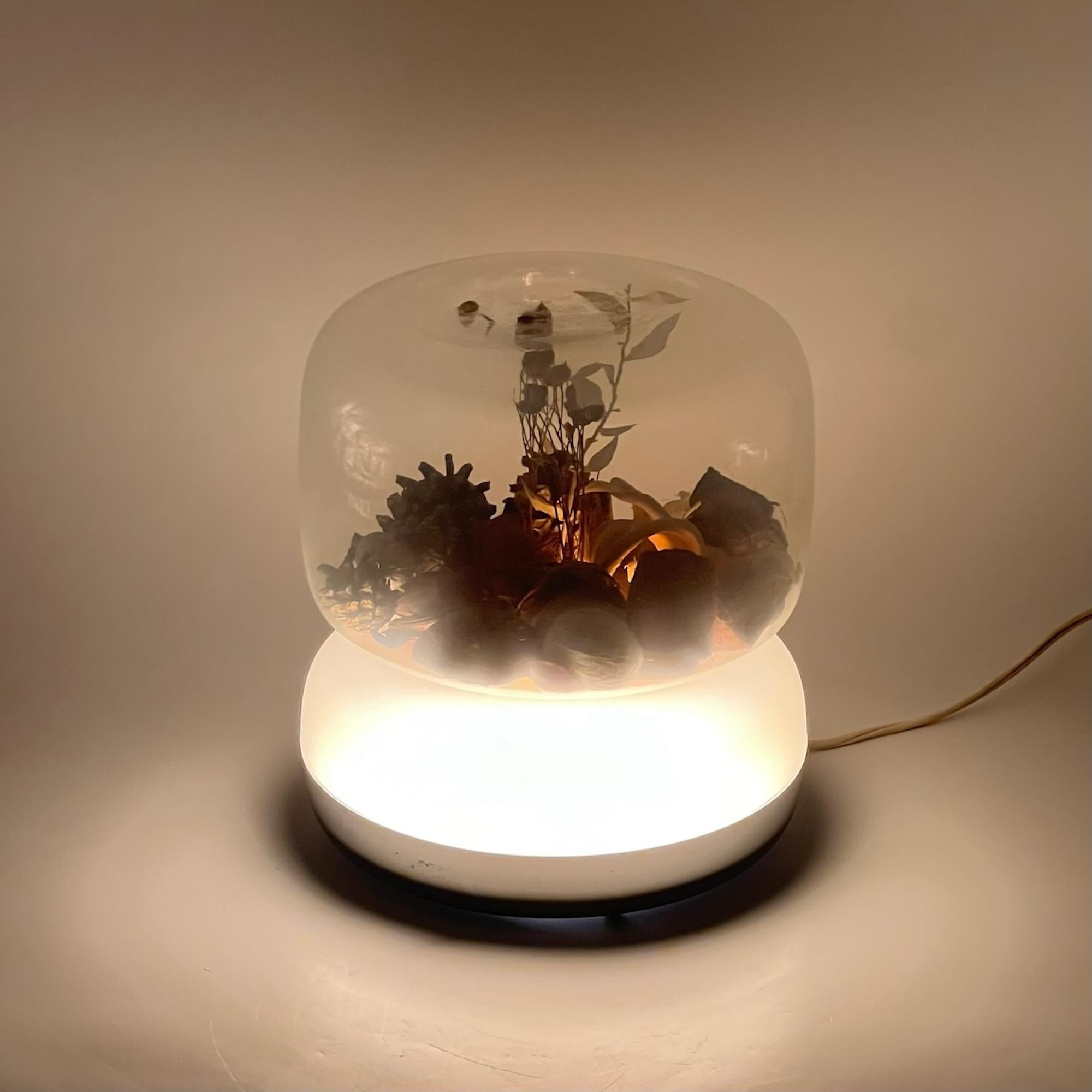 Diese seltene Space-Age-Lampe mit ihrem cremefarbenen Kunststoffsockel und der großen klaren Glaskugel entführt Sie in eine Welt voller faszinierender Beleuchtung. Das einzigartige Design dieser Leuchte ermöglicht eine fesselnde Kombination aus