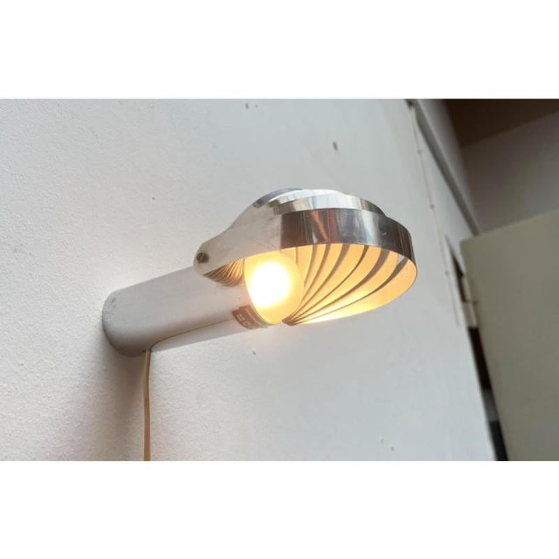 Sehr seltene Magnetleuchte des Schweizer Herstellers Temde nach einem Entwurf von Eva Renée Nele aus den frühen 70er Jahren.

Das auffälligste Detail dieser Lampe ist das Design des Lampenkopfes. Gebogene Metallstreifen umgeben die Lampe und können