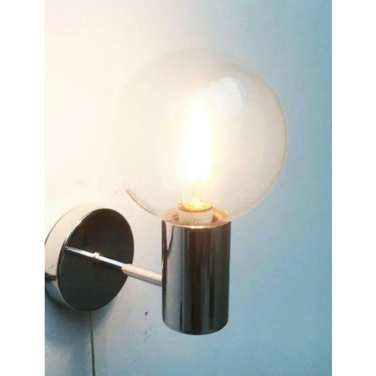 Mid century wall lamp from staff according to a design by the japanese designer motoko ishii.

a special element is the screwable glass ball, which protects the lamp and optically enlarge it. The actually small e14 lamp gets the appearance of a