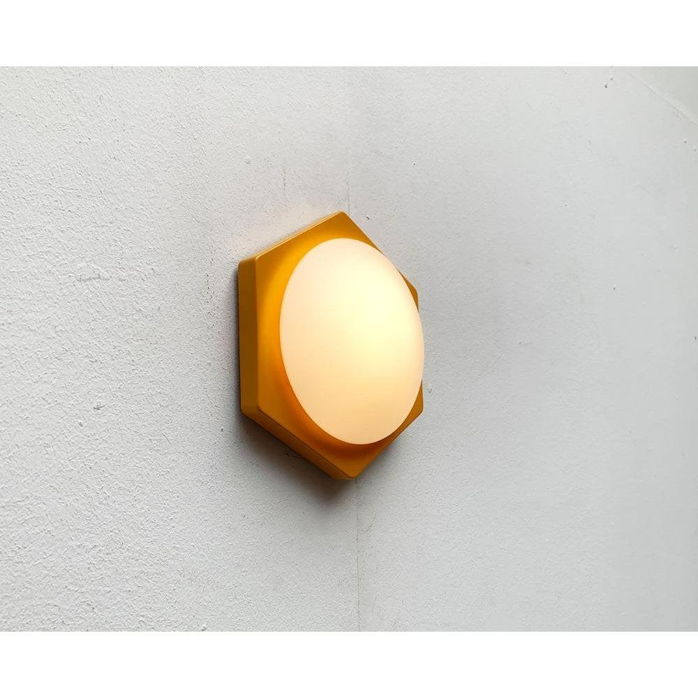 Aplique sencillo de Paul Neuhaus según un diseño de Rolf Krüger.

La luminaria consta de una placa base hexagonal de color sobre la que se asienta un difusor de cristal plano y redondo. El difusor de cristal es especialmente puntiagudo en el borde.
