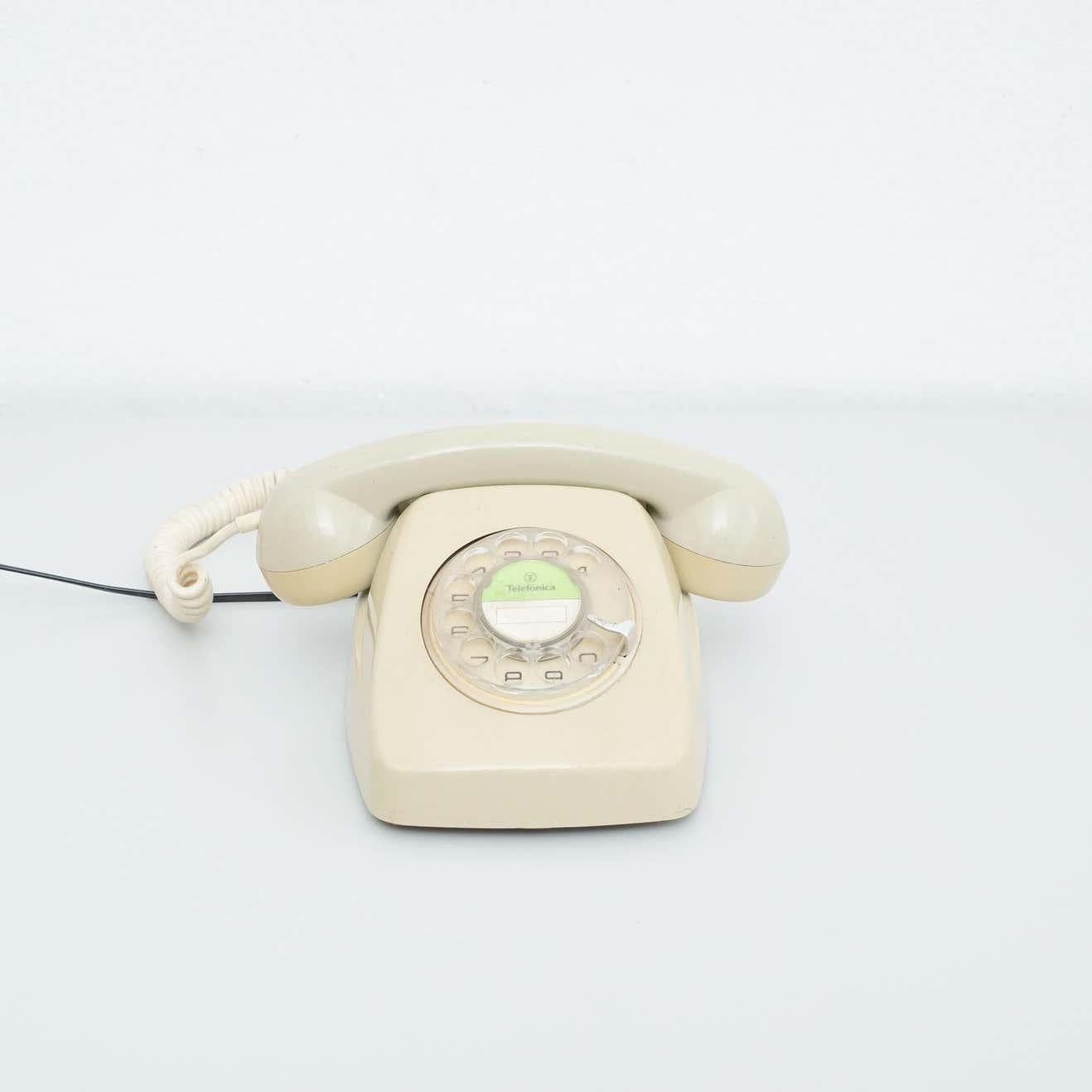 Teléfono analógico vintage fabricado por Telefónica de España, hacia 1980.    En su estado original, con pequeños desgastes propios de la edad y el uso, conserva una hermosa pátina.    Materiales:  Plástico    Dimensiones:  P 22 cm x An 24 cm x Al