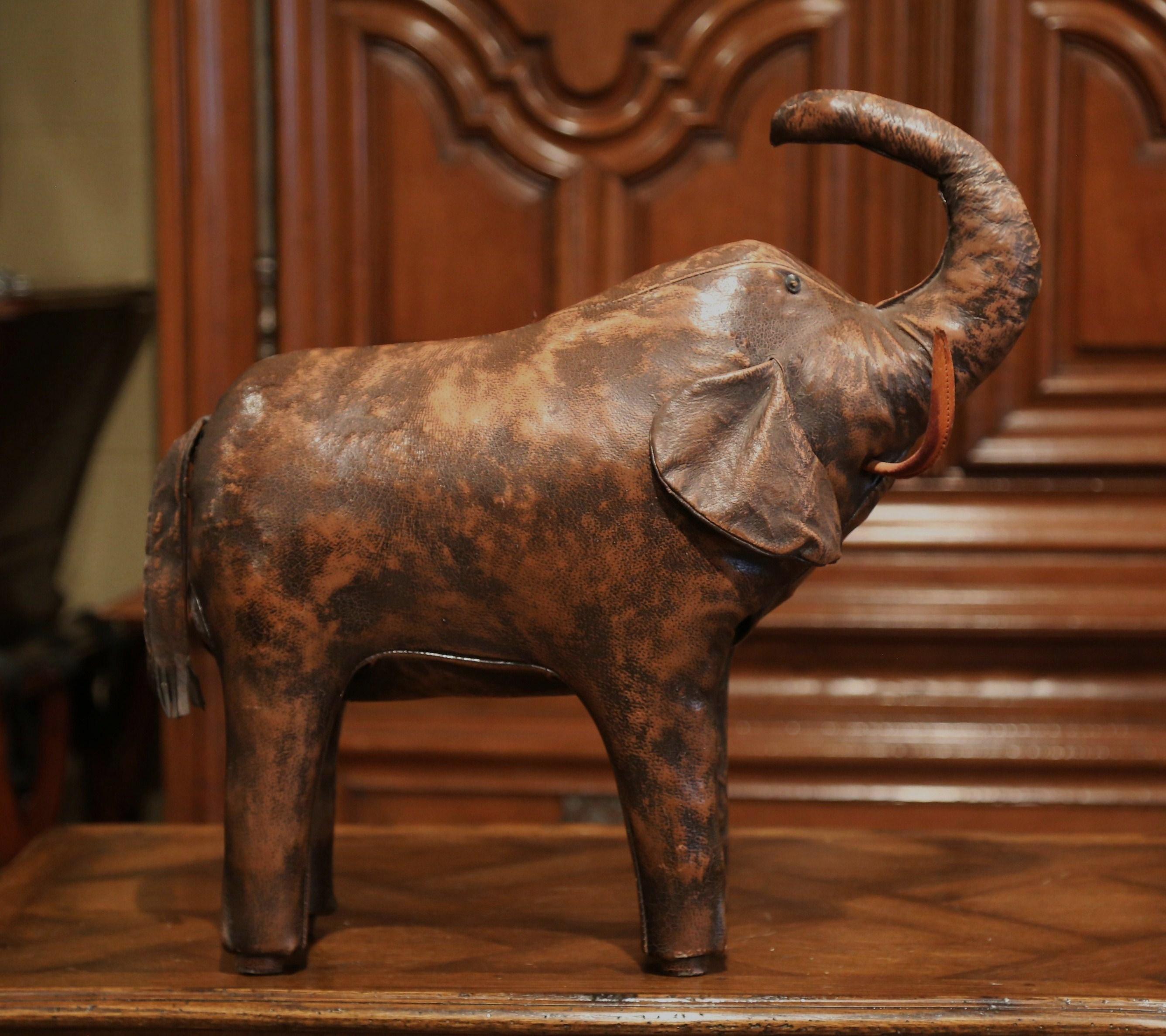 Rest your feet on this elegant stool! Crafted in Spain, circa 2000, and shaped as an elephant, the unique, freestanding, sculptural stool is upholstered with its original brown leather. The vintage pachyderm sculpture is in excellent condition and