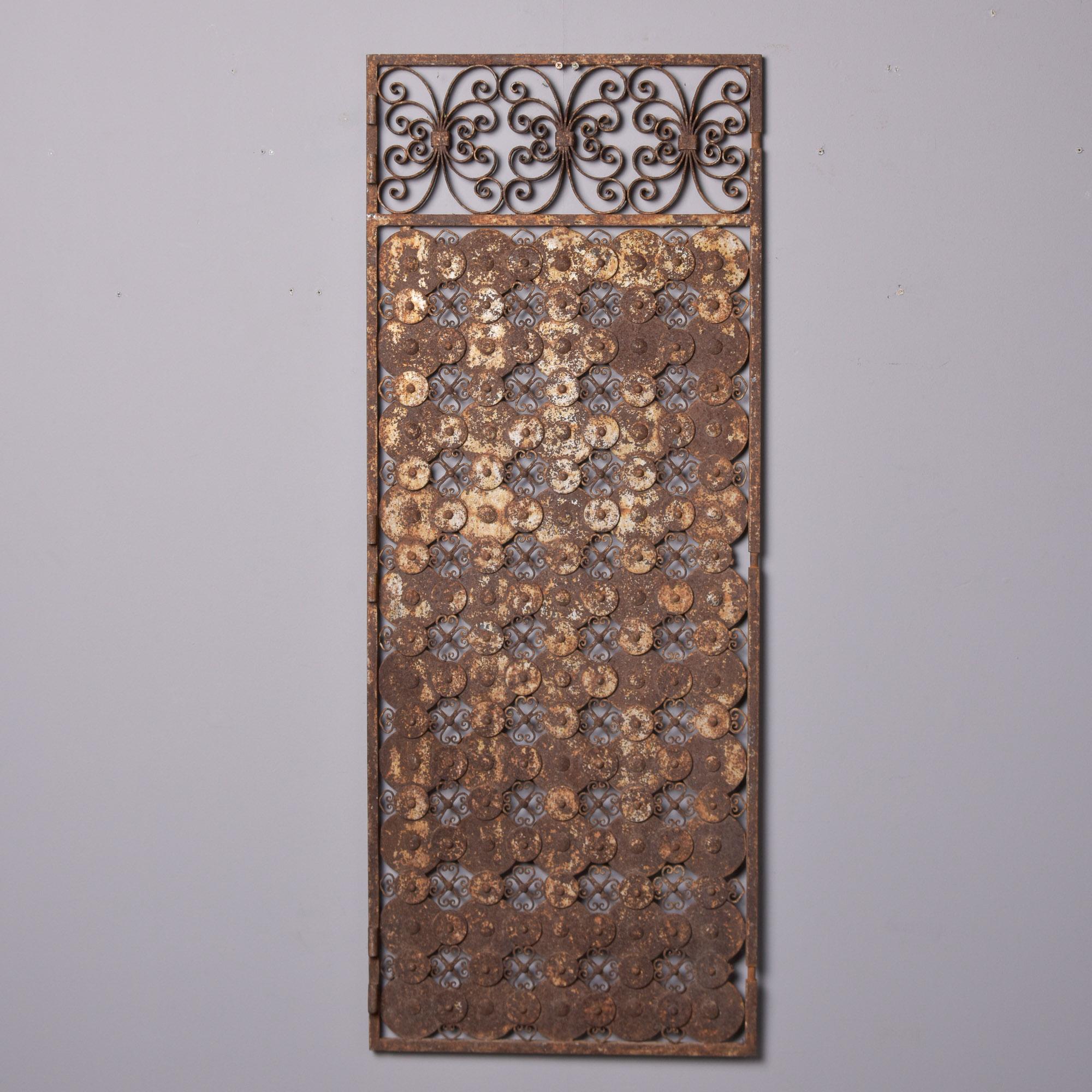 Originaire d'Espagne, ce panneau de portail en fer ajouré date de la fin des années 1960. Le haut du panneau est orné de trois volutes de fer audacieuses et ajourées, tandis que le reste du panneau est orné d'un motif en treillis de disques de fer