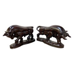 Pareja de estatuas españolas antiguas de toros de carga talladas