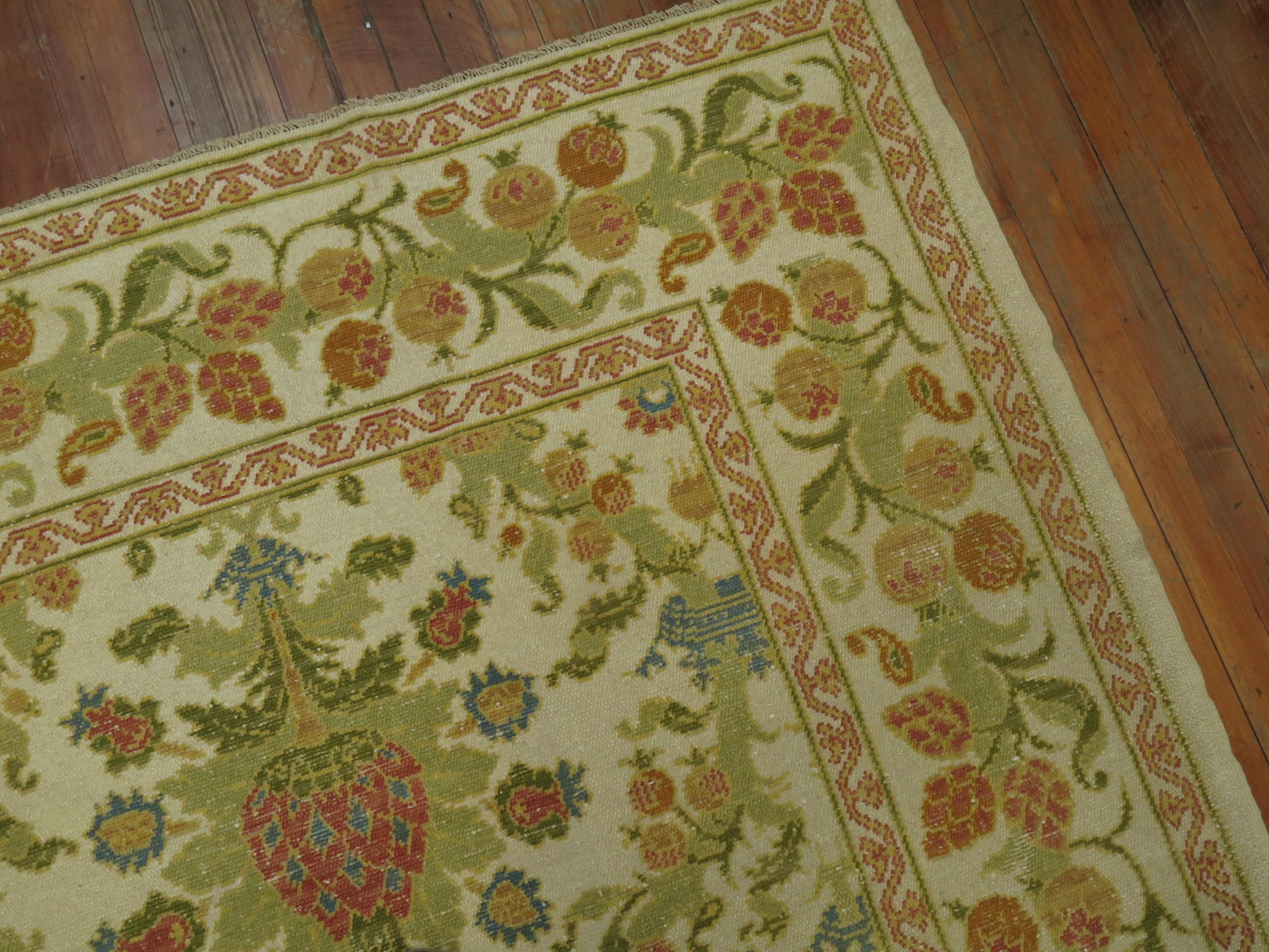 A room size Spanish rug. Ivory field, accents in green, blue, raspberry and orange.