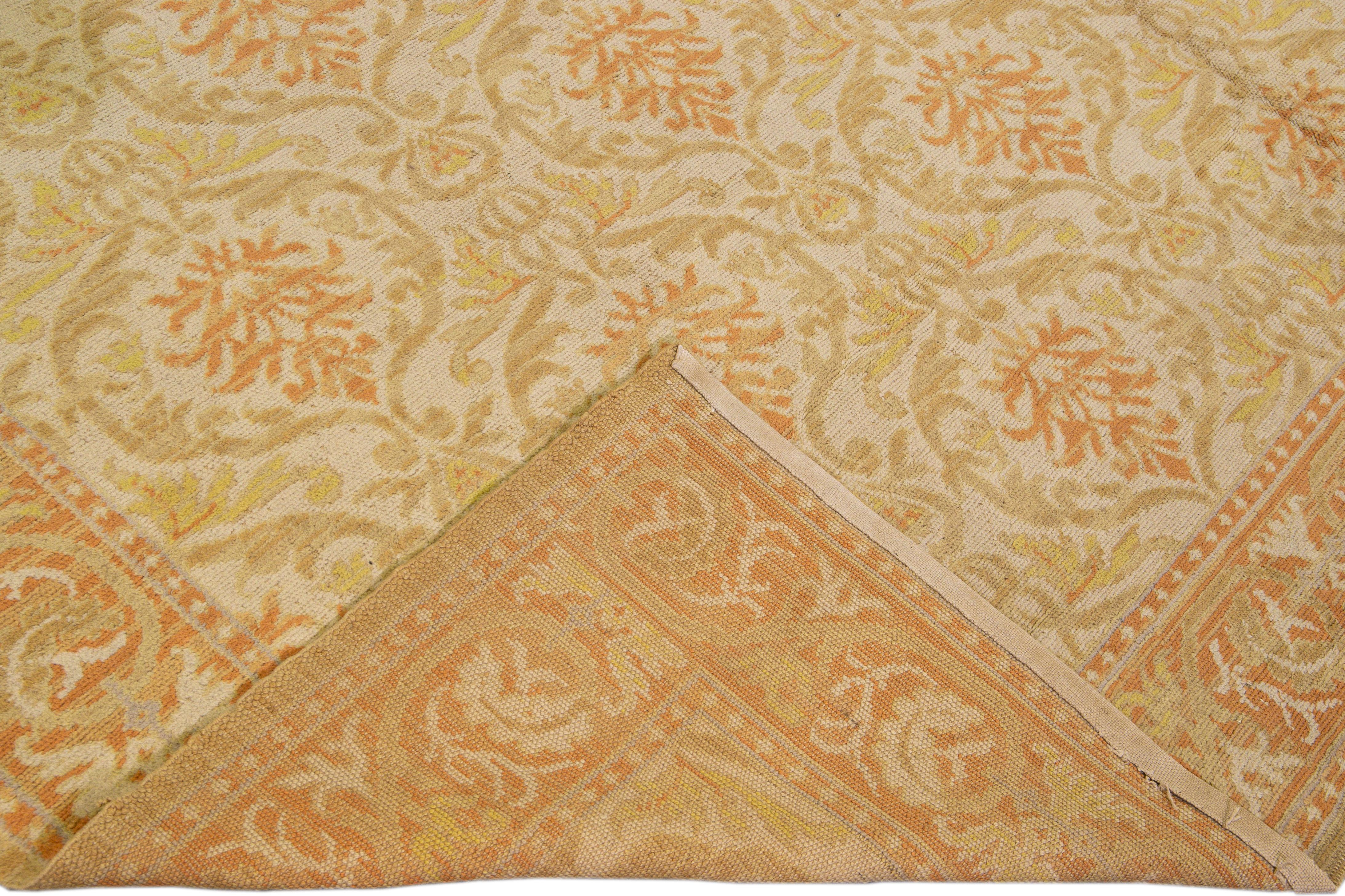 Beautiful vintage Spanish hand-knotted wool rug with the beige field. This Spanish rug has tan, yellow, and orange accents in an all-over geometric floral pattern design. 

This rug measures 10' x 17'7