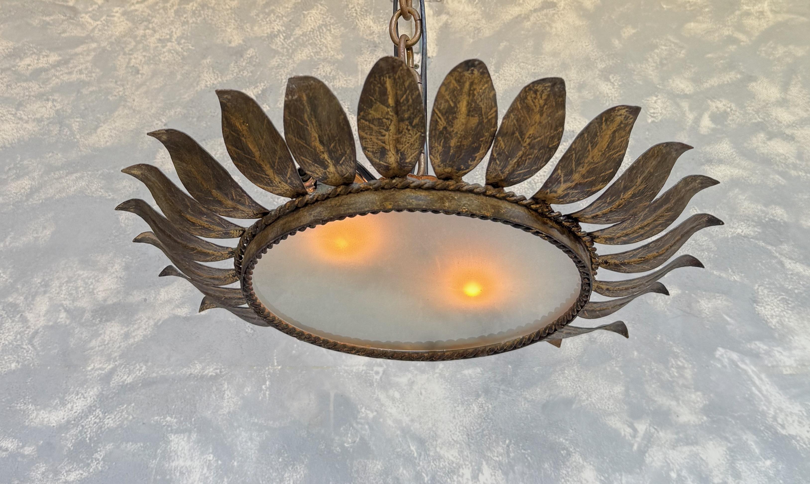 Ce remarquable plafonnier encastré espagnol, datant des années 1950, est fabriqué en métal doré richement patiné avec une sous-couche sombre qui met en valeur sa finition appliquée à la main. Le design sculptural présente des motifs de feuilles