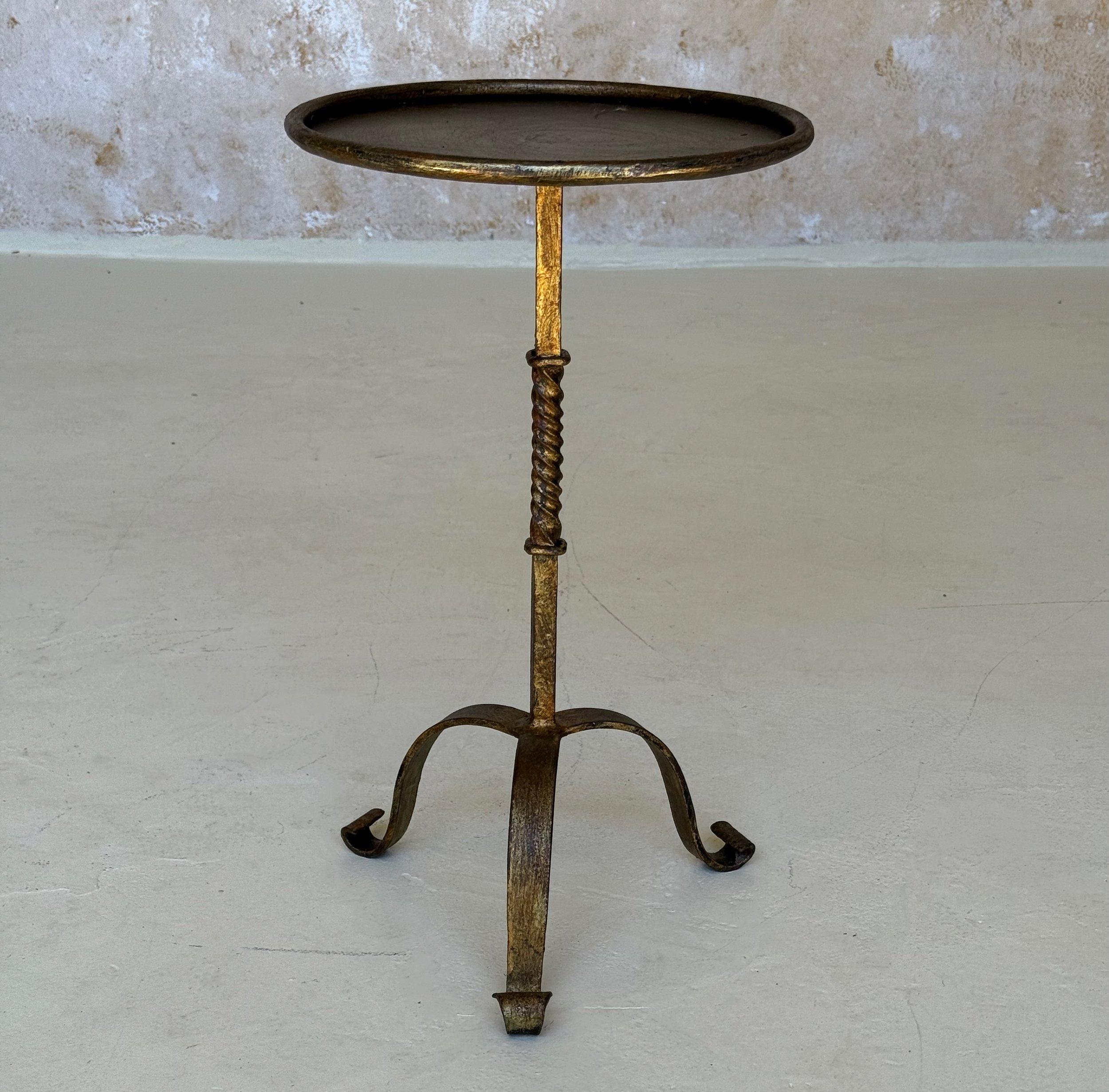 Cette petite table d'appoint en fer espagnol des années 1950 mesure 19 pouces de hauteur et 11 pouces de diamètre, ce qui en fait la taille idéale pour votre café du matin ou votre cocktail de fin de journée. Elle présente une tige carrée avec un