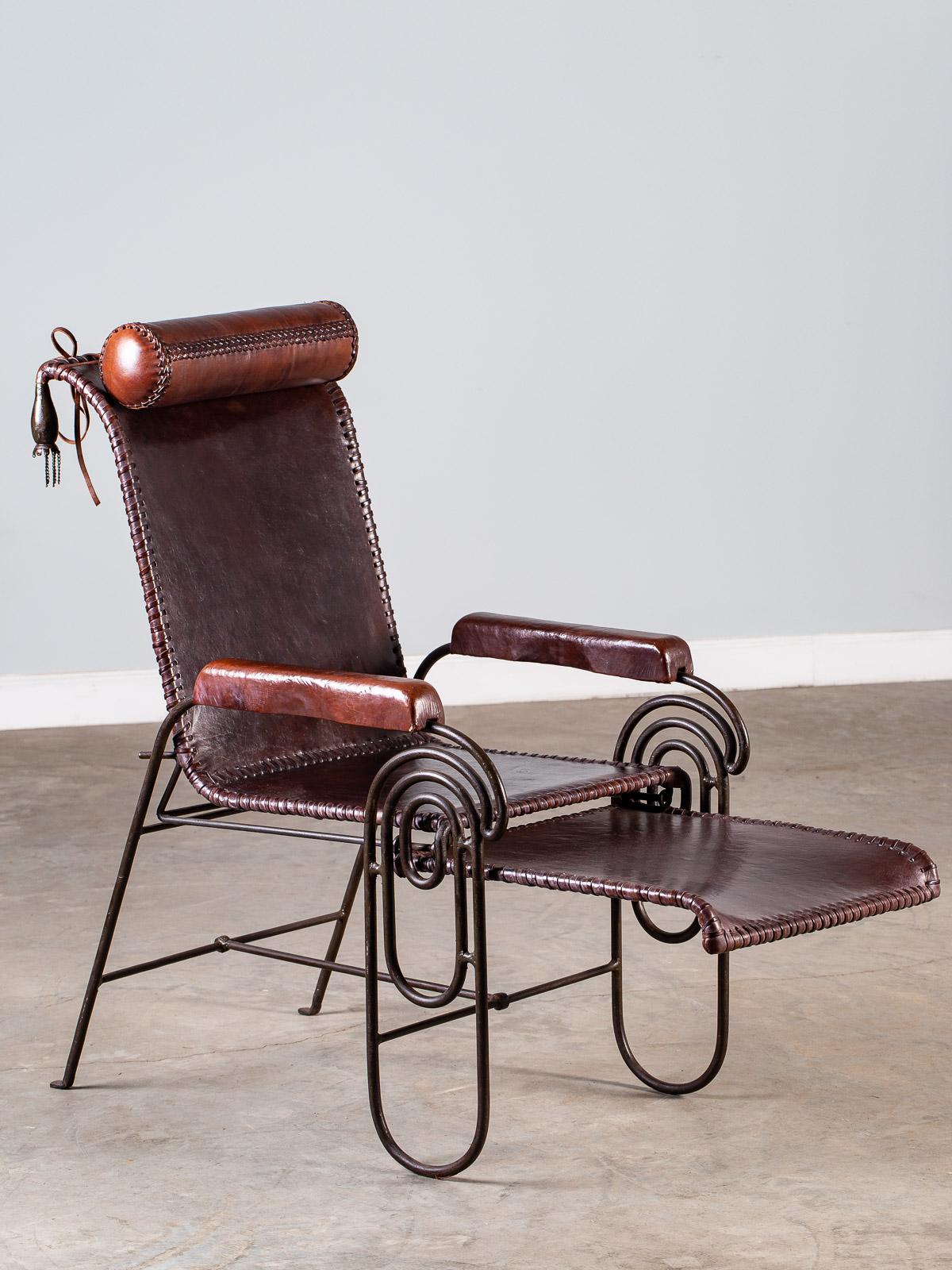 A fantastic vintage Spanish solid iron and leather armchair circa 1950 having a pull out extension as well as a full size roll pillow. This unique chair has a striking silhouette when seen from every direction. Because the frame is made from solid