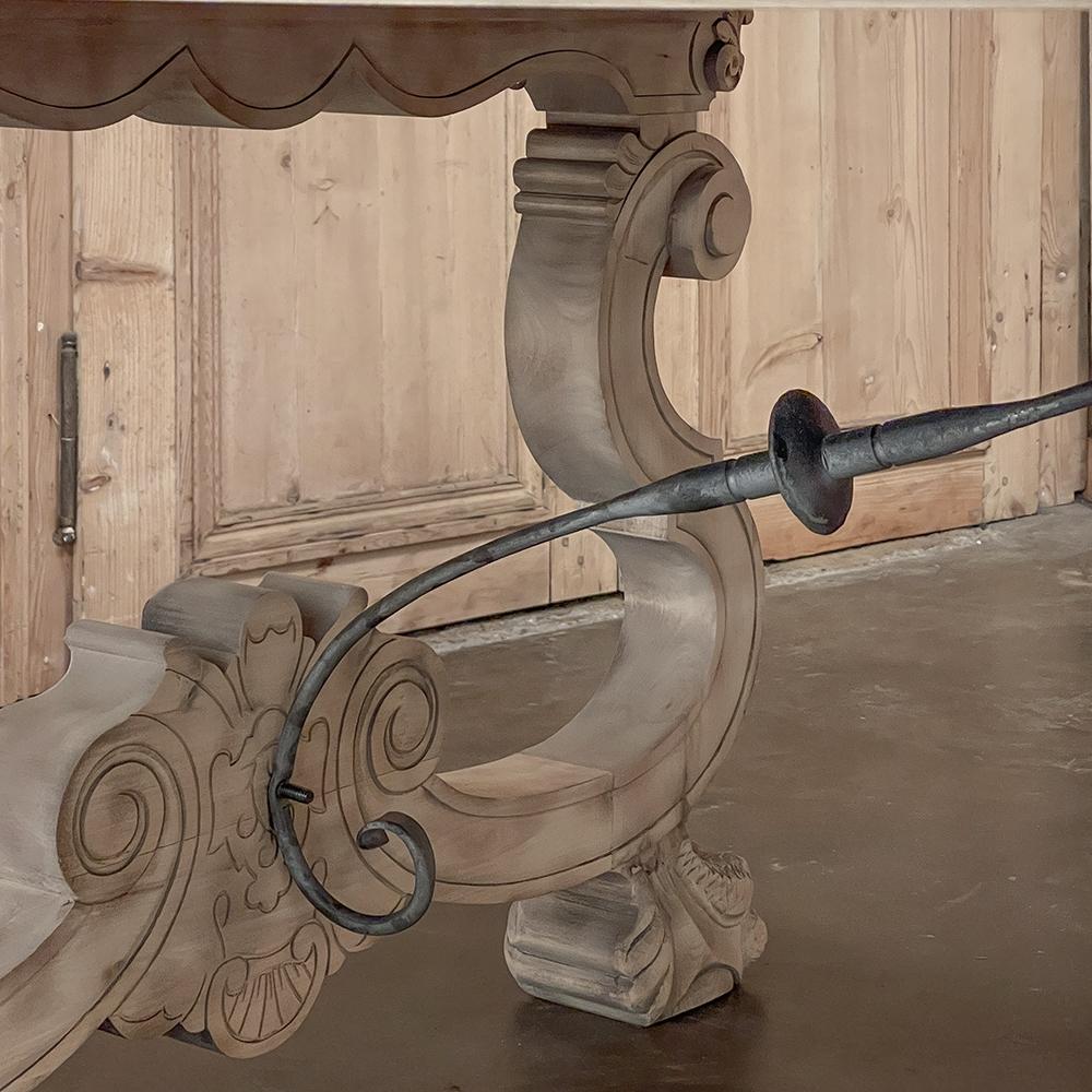 La table à manger vintage de la Renaissance espagnole rappelle les années glorieuses de la Renaissance, avec des supports de jambe exubérément sculptés de chaque côté en forme de lyre complexe, situés sur des pieds élégamment fleuris, et reliés par