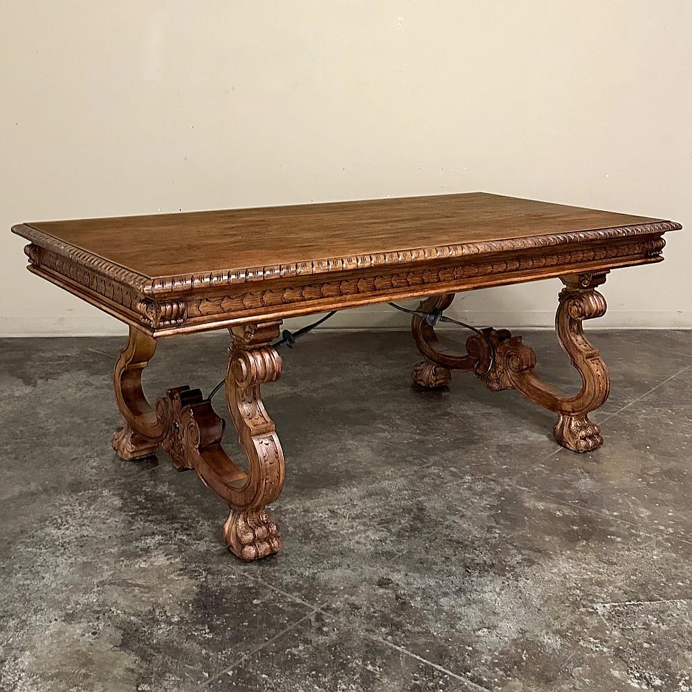 La table à manger vintage de la Renaissance espagnole rappelle les années glorieuses de la Renaissance, avec des supports de jambe exubérément sculptés de chaque côté en forme de lyre complexe, situés sur des pieds élégamment fleuris, et reliés par
