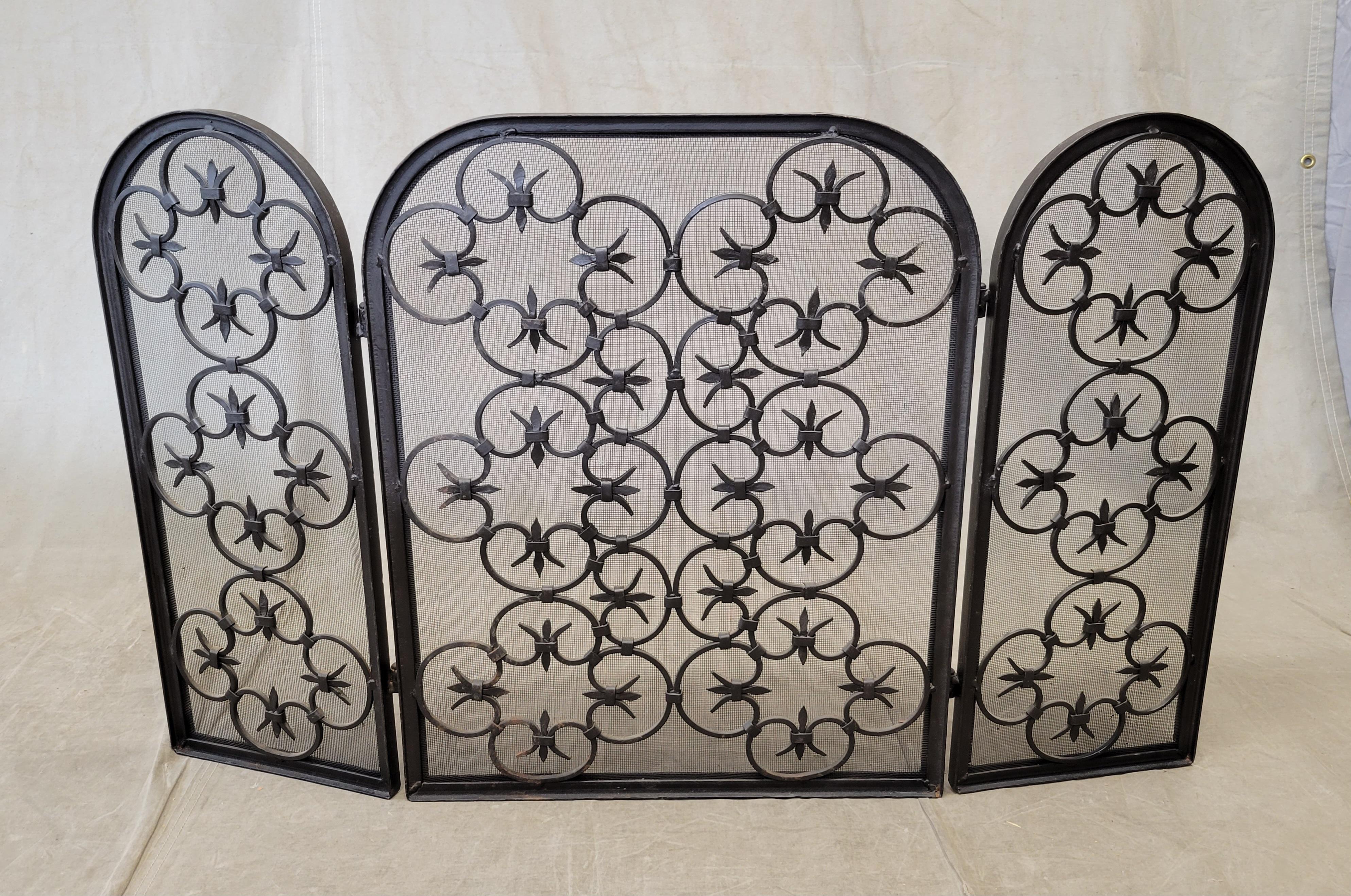 An elegant and functional vintage Spanish revival wrought iron folding fireplace screen. Comprised of C-scrolls of dark brown black iron backed by screening. Hinges open and close easily. This is a heavy, sturdy screen weighing 45 pounds.
Flat