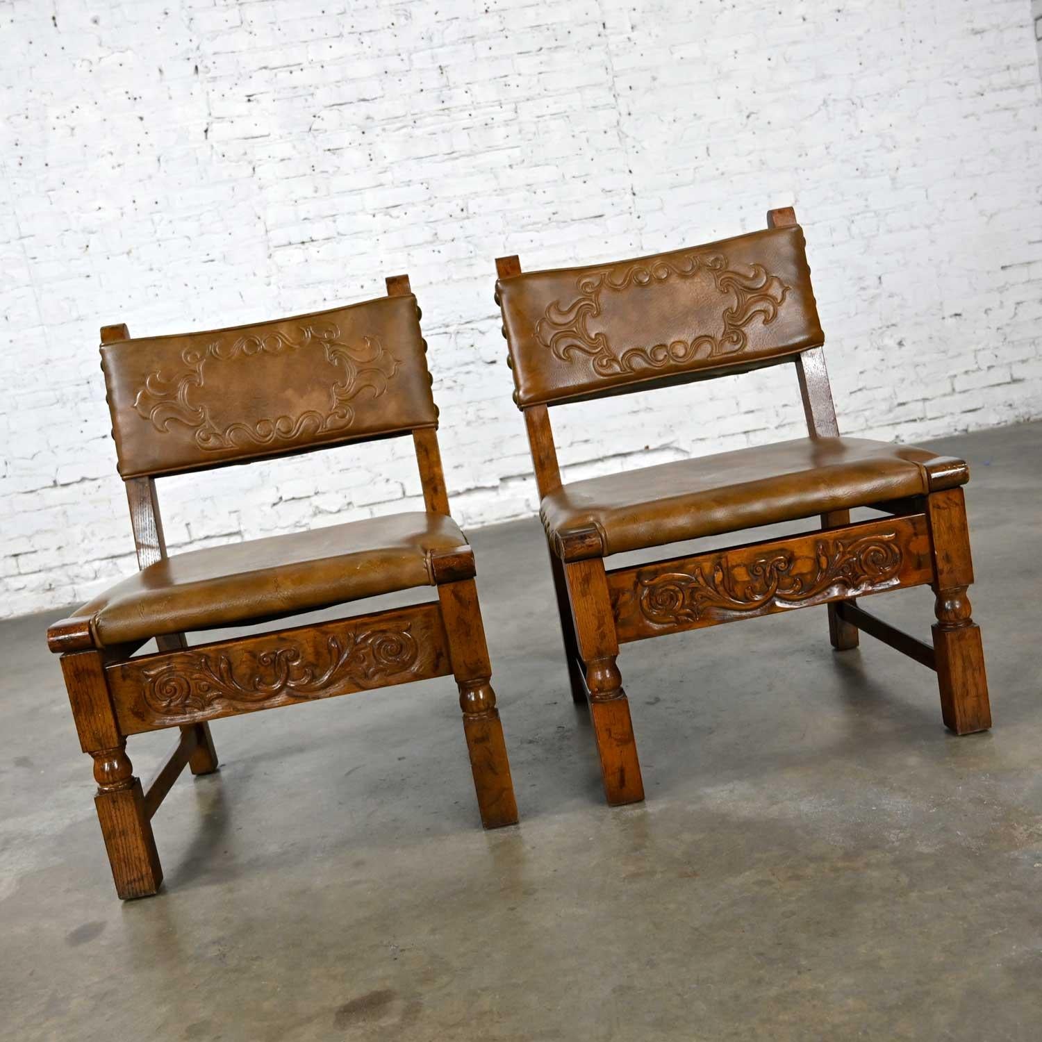 Fabulous vintage Spanish Revival oak pair of chairs with tooled cognac faux leather or vinyl seat backs in the style of Artes De Mexico Internationales. Beautiful condition, keeping in mind that these are vintage and not new so will have signs of