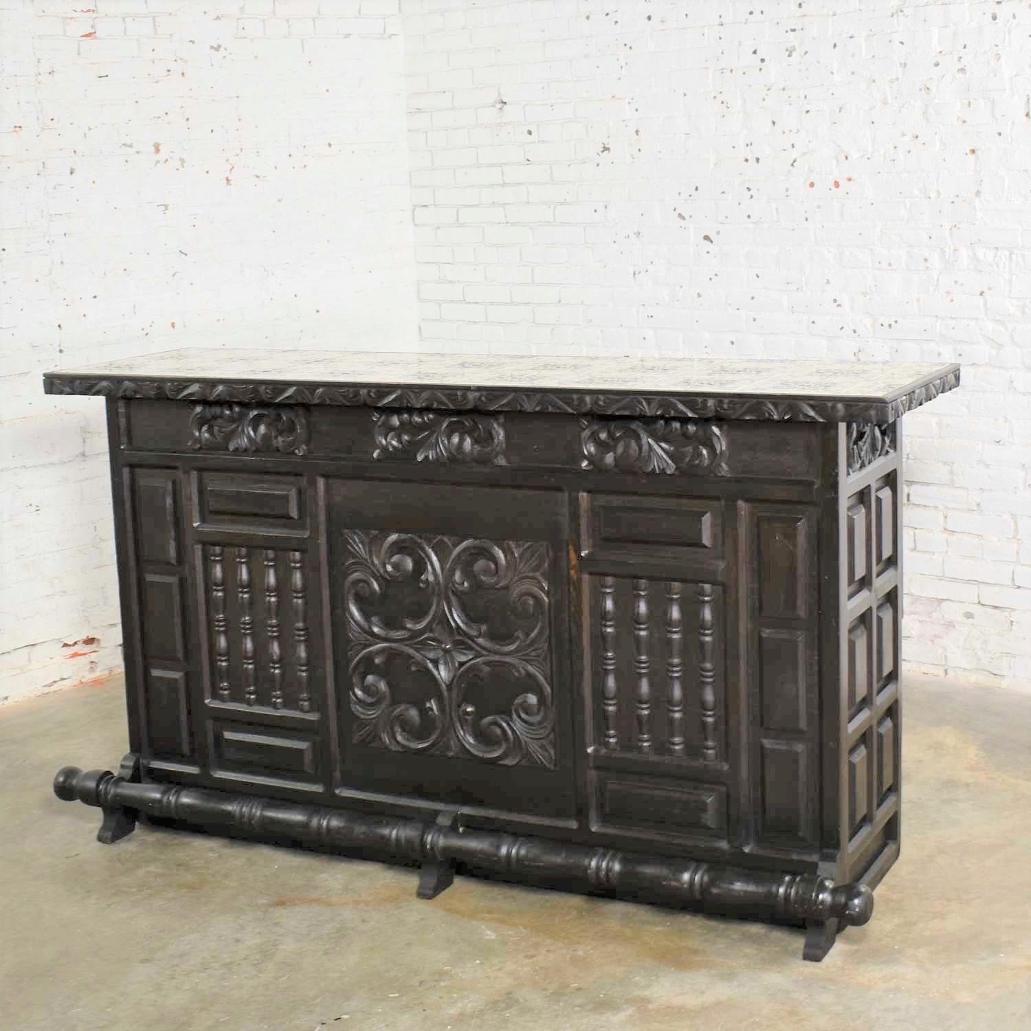 Handsome vintage Spanish Revival style dry bar with an inlaid tile top. It is unmarked but done in the style of Artes de Mexico International, SA. It is in wonderful vintage condition but not without flaws. The wood has a nice patina that can only
