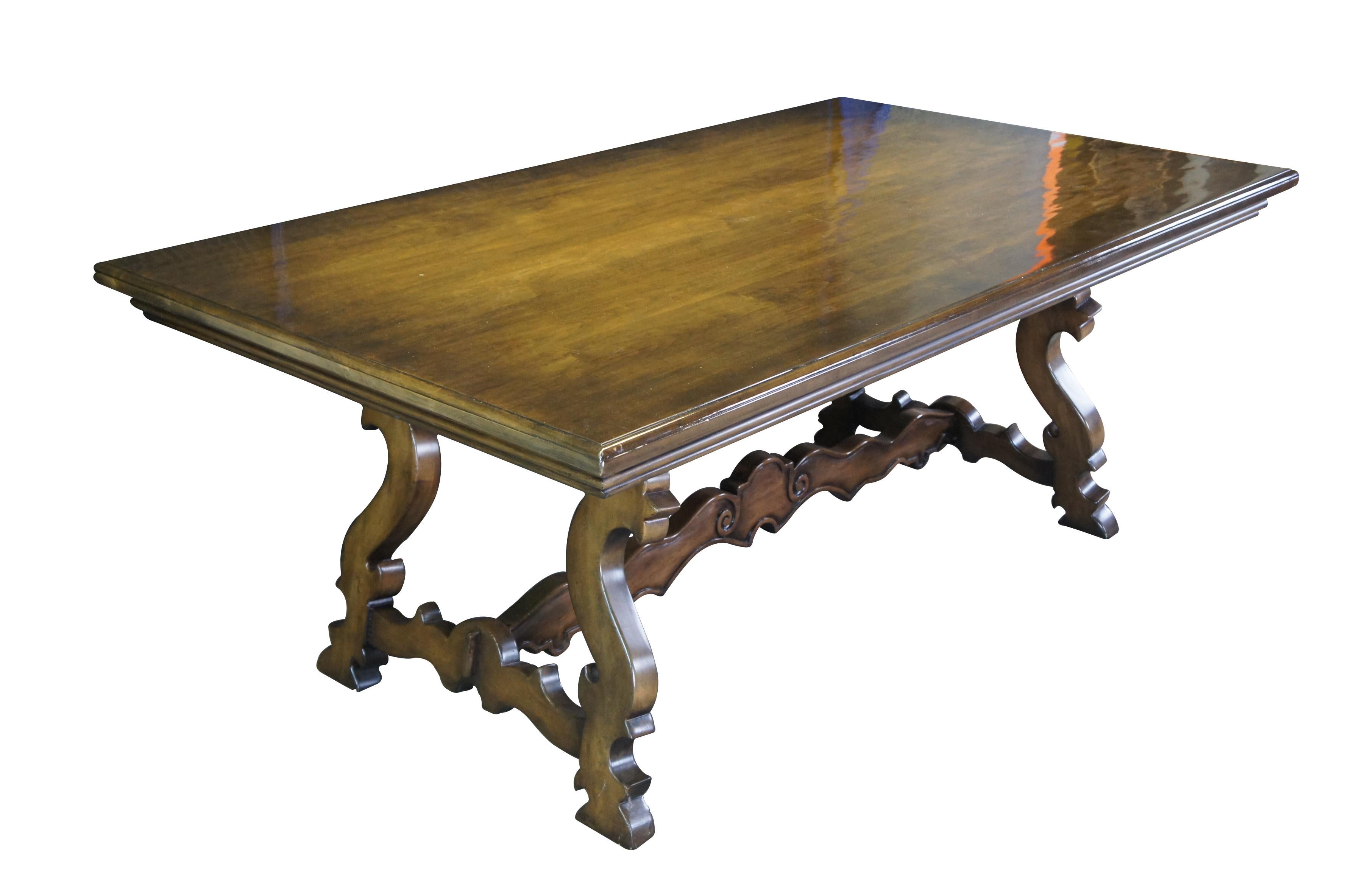 Vintage Spanish Revival / Tuscan / old world dining table.  Made of walnut featuring rectangular form with carved baroque serpentine legs connected by a trestle.

Dimensions:
45