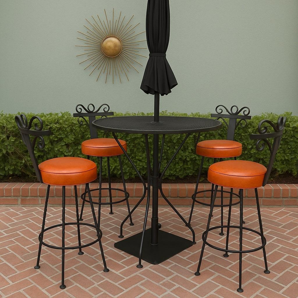 An exceptional complete vintage bar set featuring four wrought iron swivel bar stools, a matching round mesh-top bar table, and a heavy wrought iron umbrella stand. Crafted in the Spanish Revival / Hollywood Regency style, these pieces showcase bold