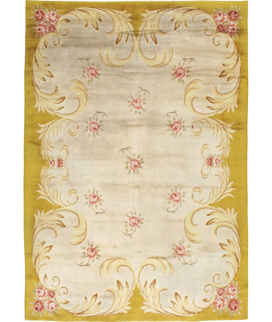 A vintage Savonnerie carpet from Spain with rose blossoms on a cream field, framed by a scrolling acanthus leaf border.
