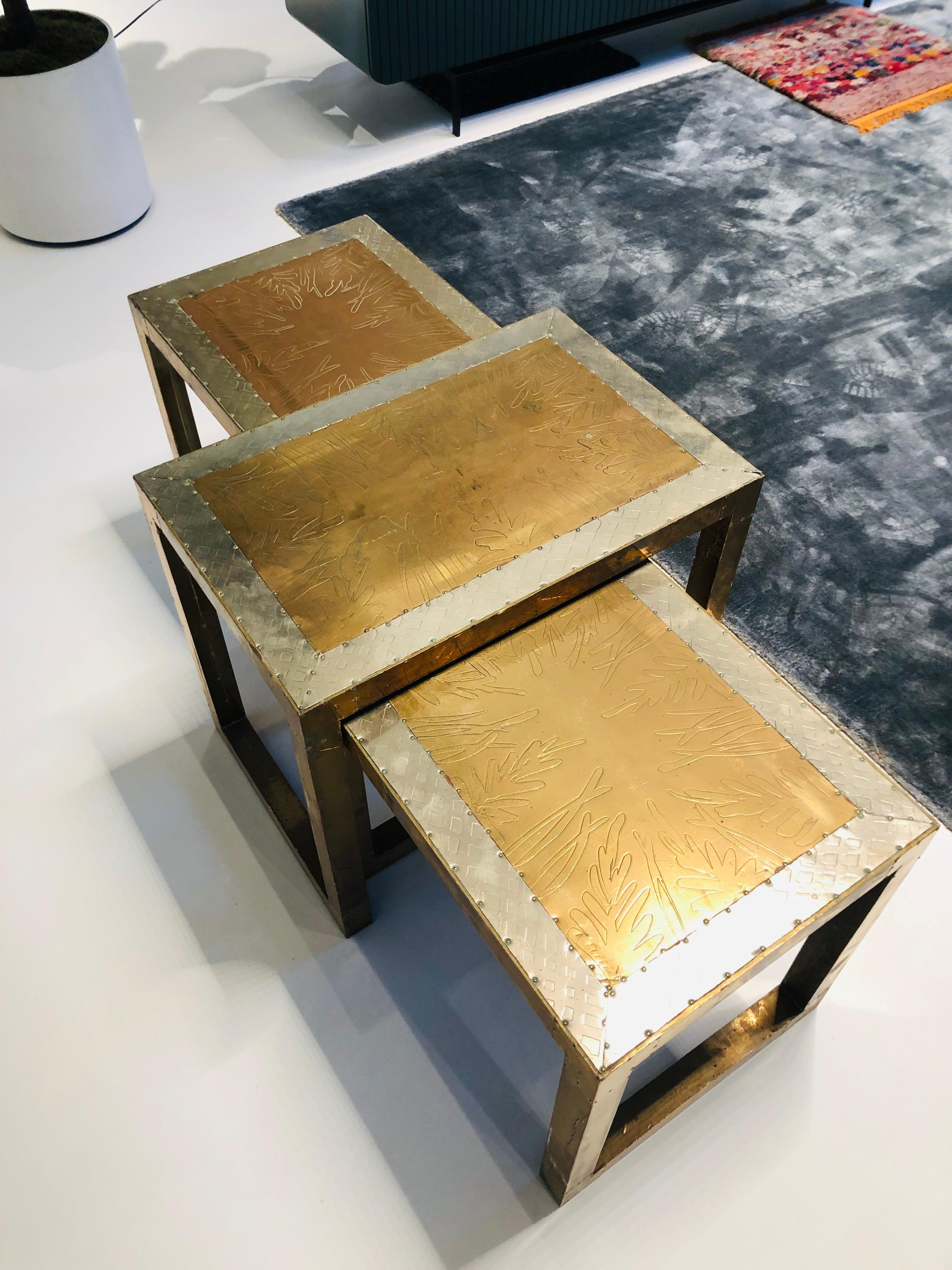 Set aus drei stilvollen niedrigen Sofatischen aus bedrucktem Metall mit stilisiertem Dekor. Entworfen und signiert von Rudolfo Dubarry, der sich in den späten 1960er Jahren in Marbella, Spanien, niederließ. 
Die Tische sind in sehr gutem Zustand