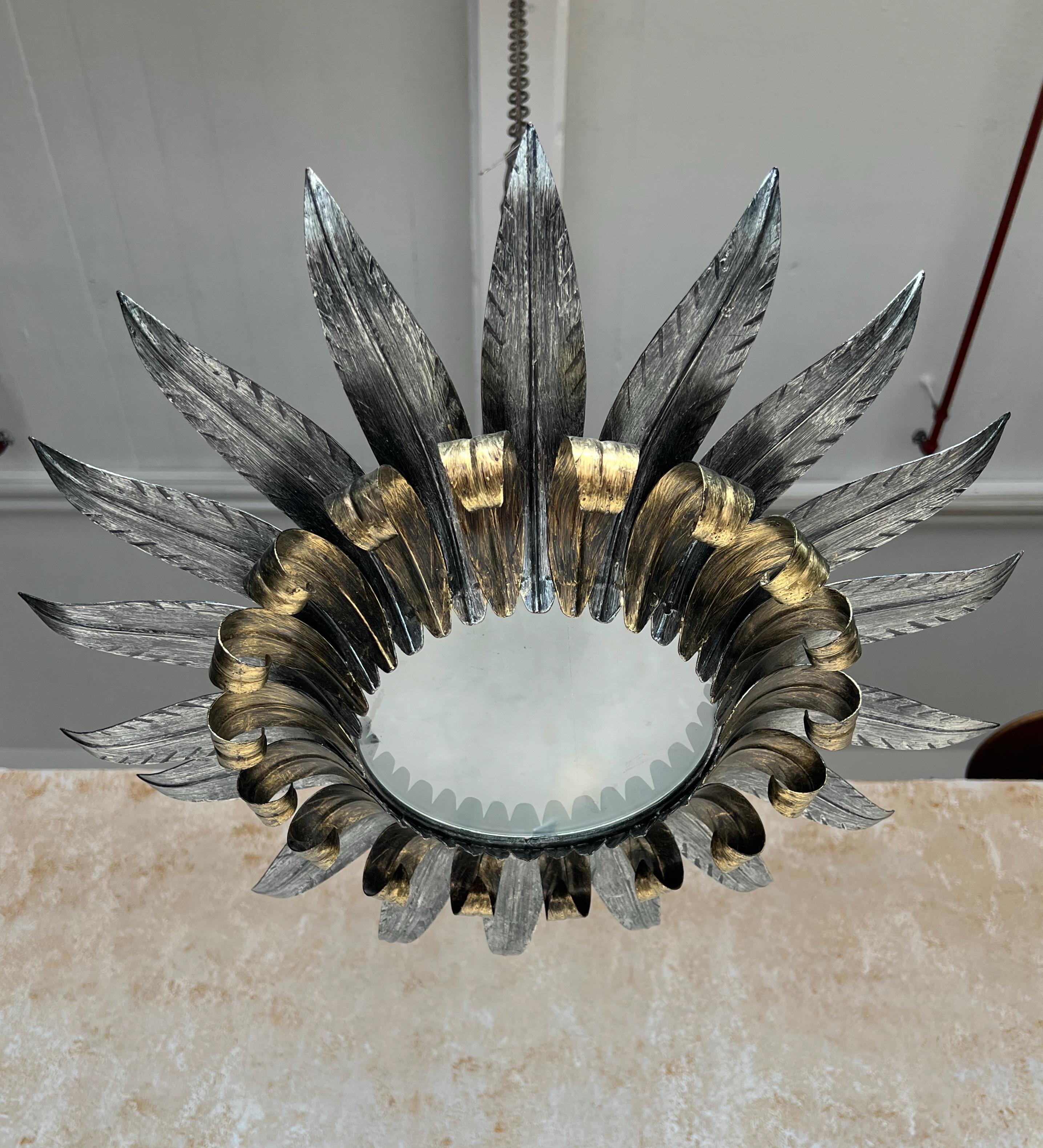 Questa splendida plafoniera spagnola in metallo dorato degli anni '50 presenta un design a doppia foglia con foglie superiori argentate che si arricciano leggermente verso l'alto e foglie inferiori dorate che si curvano graziosamente in alto e si