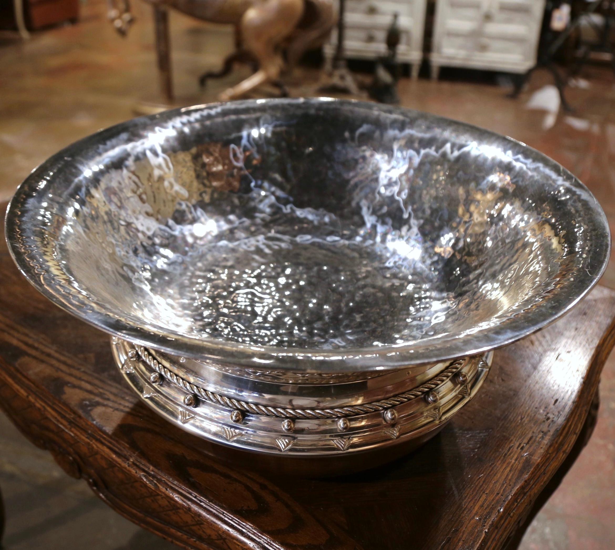 Crafted in Spain, circa 1970 and circular in shape, the handmade centerpiece features a hammered silver wide mouth bowl attached to a hand carved walnut base. The large bowl is decorated with rope details and features circular studs throughout the