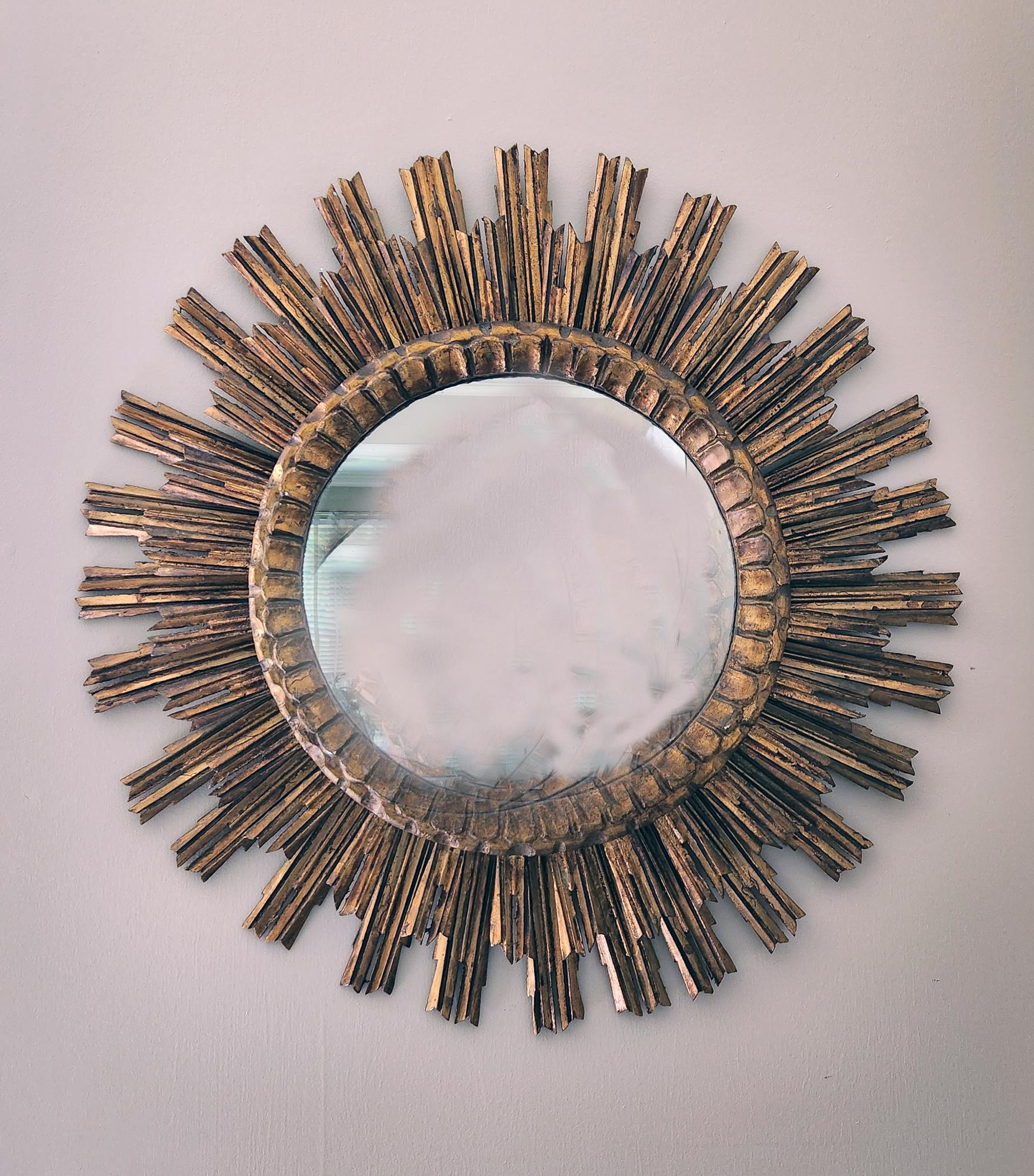 Vintage Sunburst Circular Giltwood Mirror,
Spanish,
1940s

A Spanish Baroque circular mirror with a double layered surround of shaped sun rays with overlapping radiating leaves meticulously arranged around the central mirror.

Dimensions: 29 inch