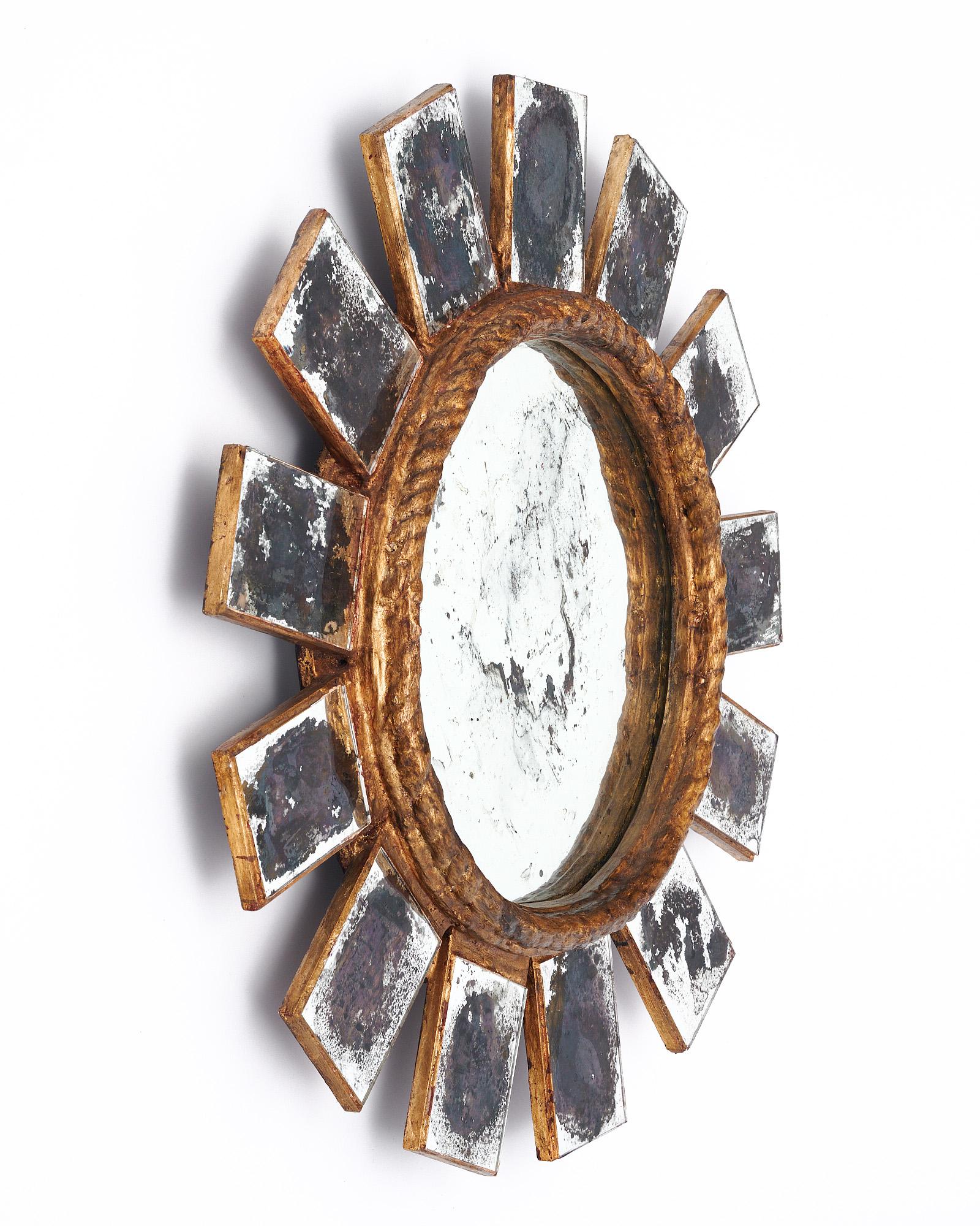 Sunburst im spanischen Stil mit einer Holzstruktur und Blattgoldbeschichtung. Die Strahlen sind mit einem antikisierenden Spiegelfurnier überzogen. Der zentrale Spiegel ist rund.
