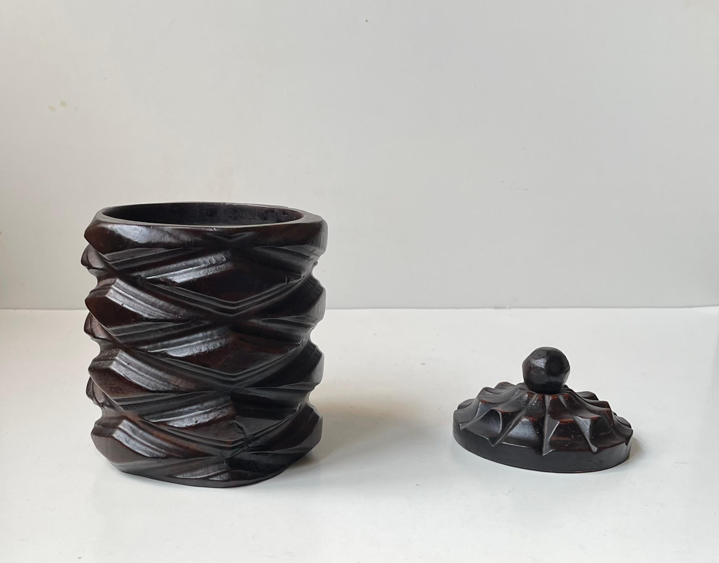 Porta tè o barattolo per il tabacco realizzato in modo decorativo da un unico tronco di legno. Realizzato a mano in Spagna nel periodo 1960-80 circa. C'è quasi qualcosa di simile ad Axel Salto nel suo motivo a rilievo profondamente intagliato. Il