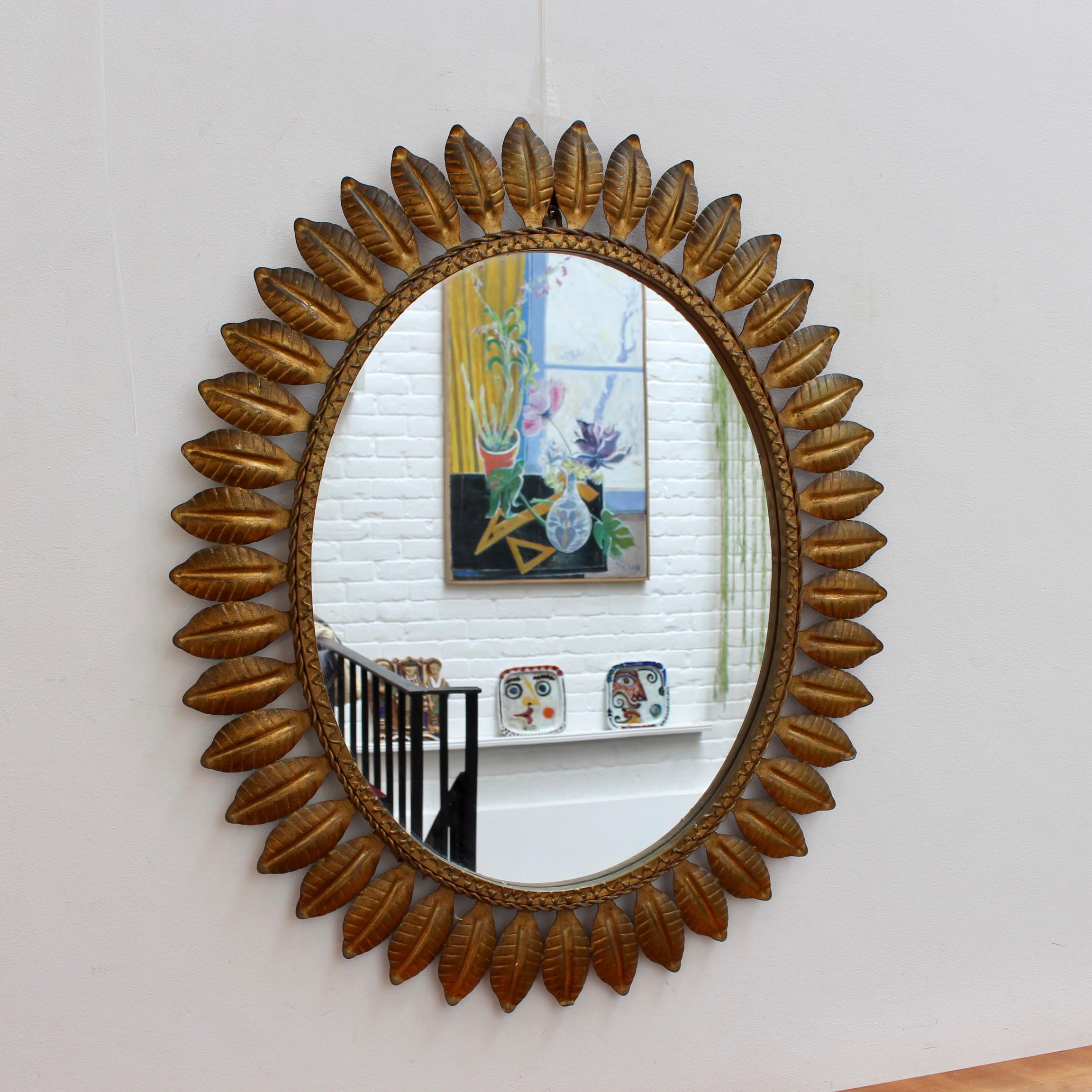 Vintage Spanish tôle sunburst mirror with copper patina and leaf motif rays coupled with a rope-pattern mirror border. In good overall condition. Some minor age-related blemishes appear on the leaf decor and mirror glass reflecting (excuse the pun)