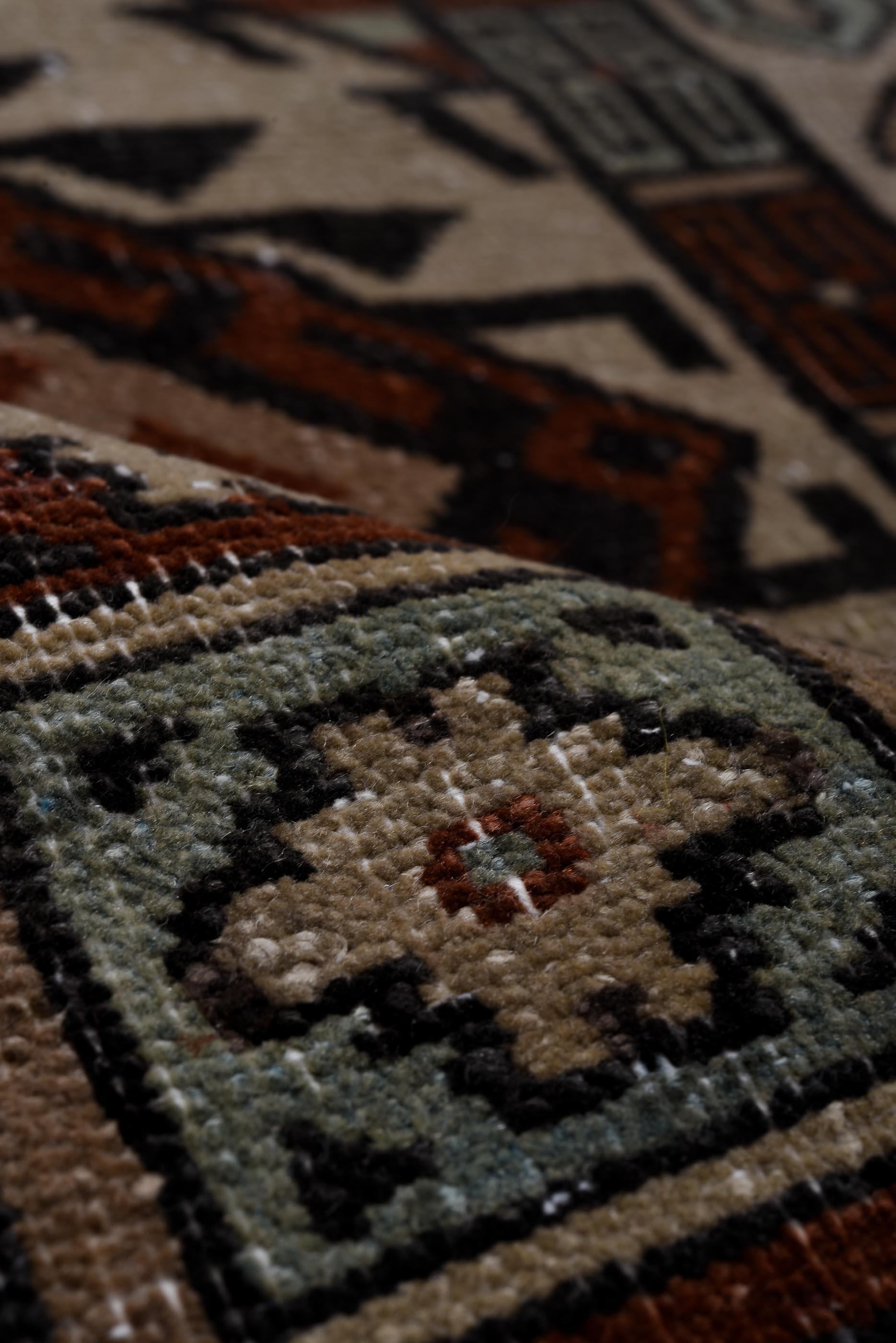 Ce tapis Sparta vintage présente une composition architecturale audacieuse de compartiments géométriques imbriqués, avec des médaillons en escalier et des motifs inspirés des kilims, dans des tons rouille, noyer, ivoire et bleu ciel pâle. Le motif