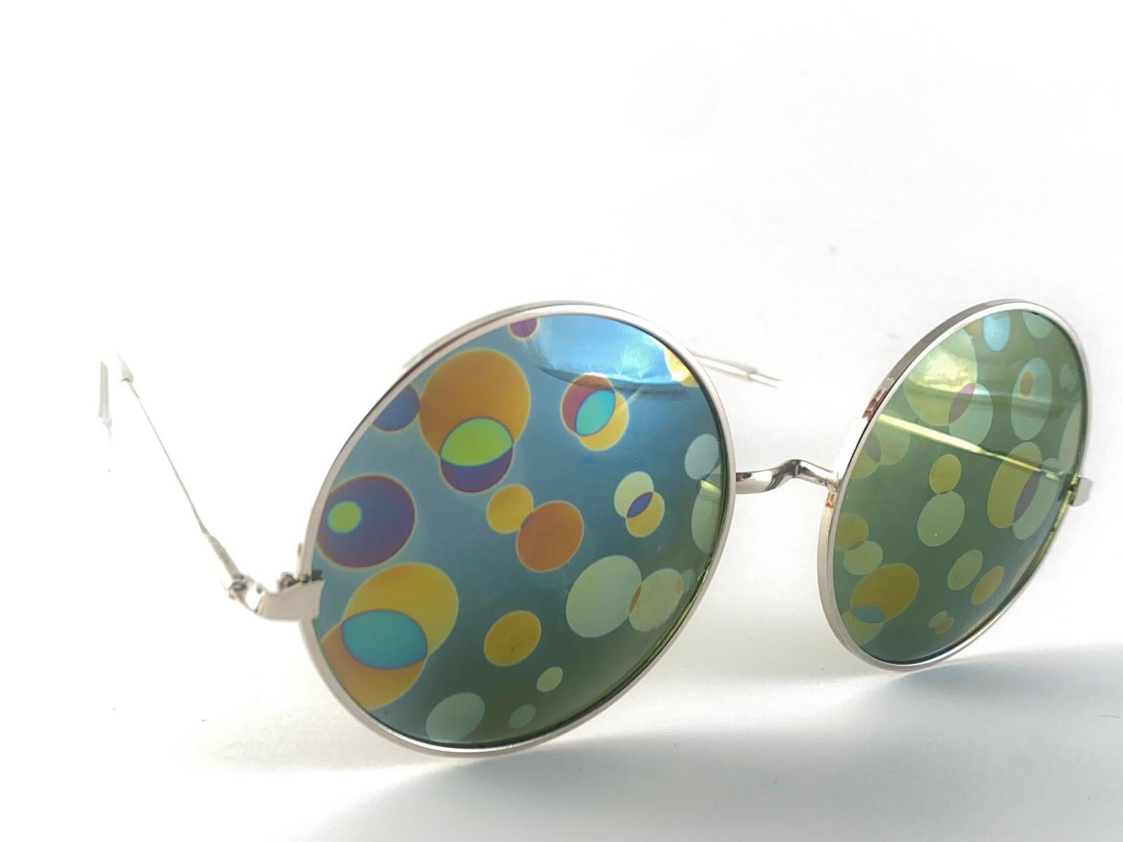 Vintage Spex Appeal Monture psychédélique ronde surdimensionnée en argent portant une paire de points colorés imprimés et imbriqués.  Lunettes de soleil 1970's Made In Usa.

Cette paire présente une légère usure due à près de 60 ans de stockage. 