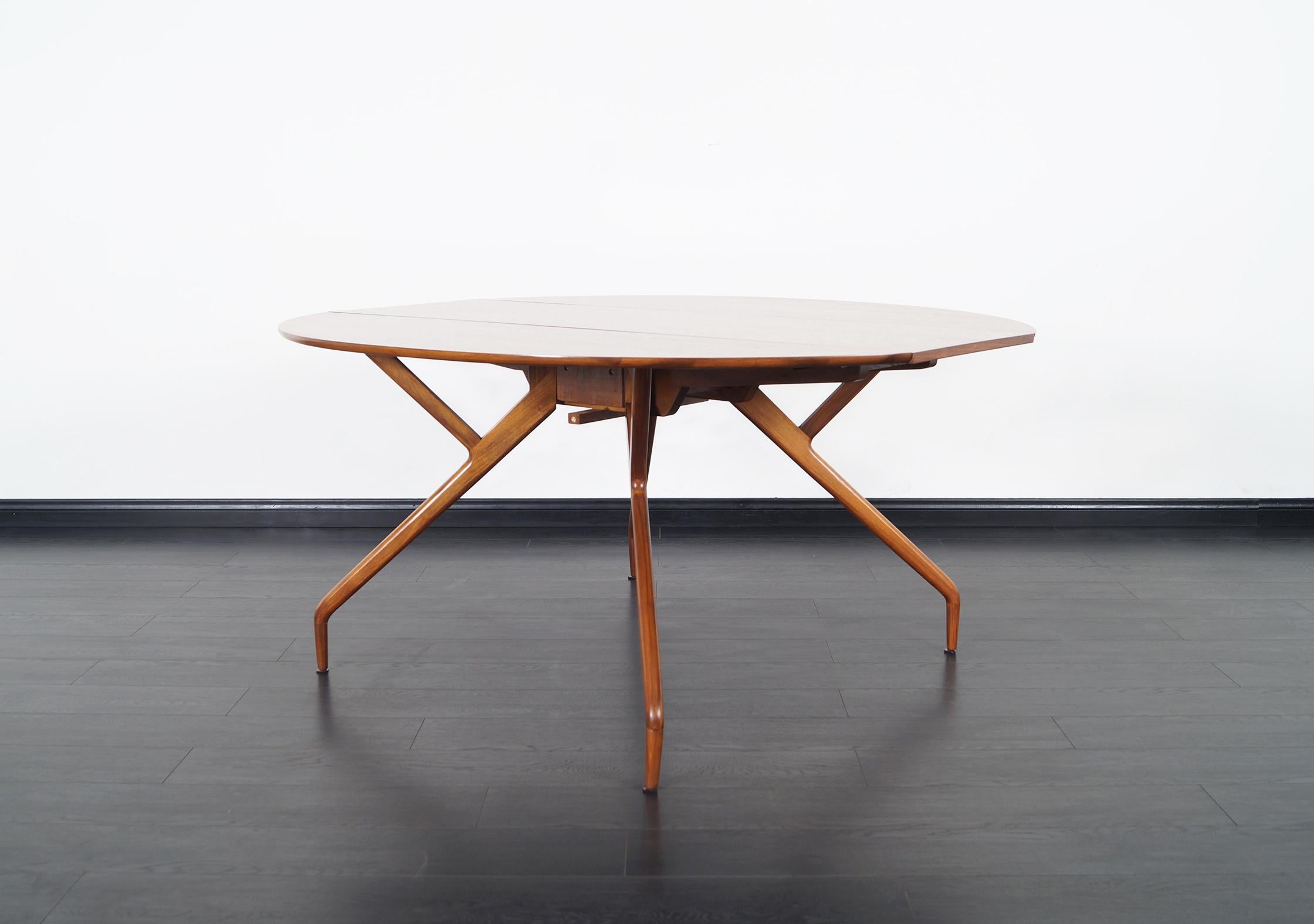 Wonderful vintage “Spider” dining table designed by Ed Frank for Glenn of California in United States, circa 1950s. The table is made from walnut that expresses elegance through the grains of the wood that make up the table. It has a very particular