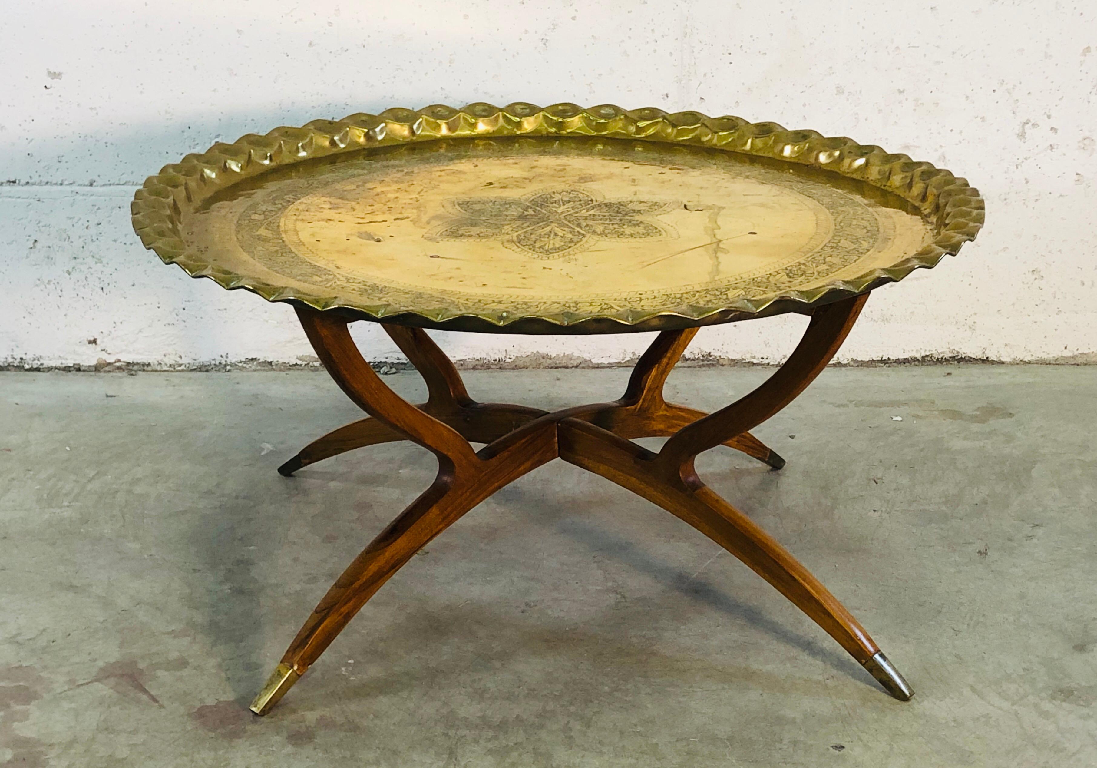 Vintage Mid-Century Modern spider leg coffee table with a Moroccan brass tray top that has a floral design. The base folds up for easy storage and the feet tips are also accented in brass. No marks.