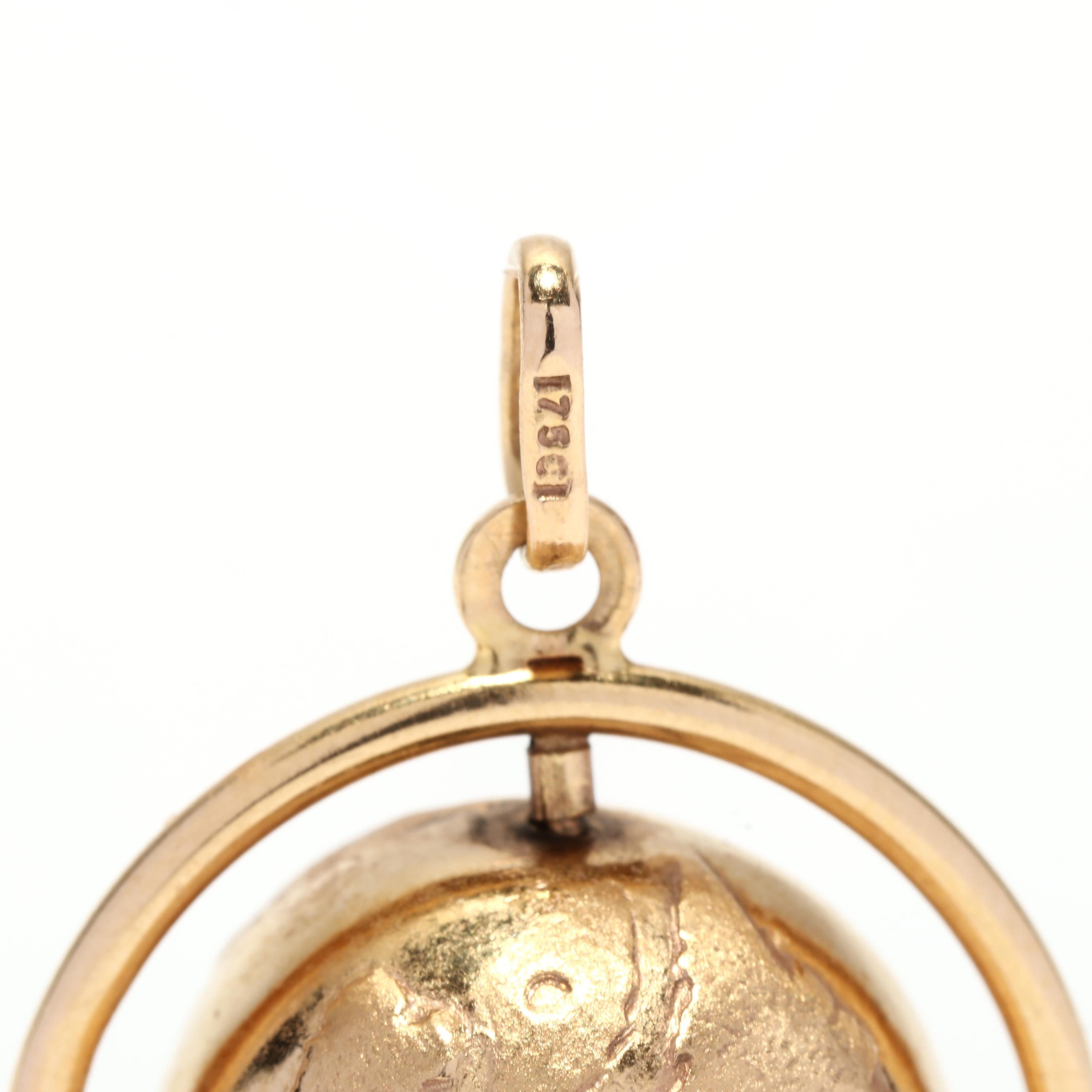A vintage 18 karat yellow gold spinning globe charm. This large charm features a round sphere that depicts the world with engraved detailing that spins in a circular border and with a thin bail.

Length: 1 3/8 in.

Width: 1 in.

Weight: 4.6 dwts. /