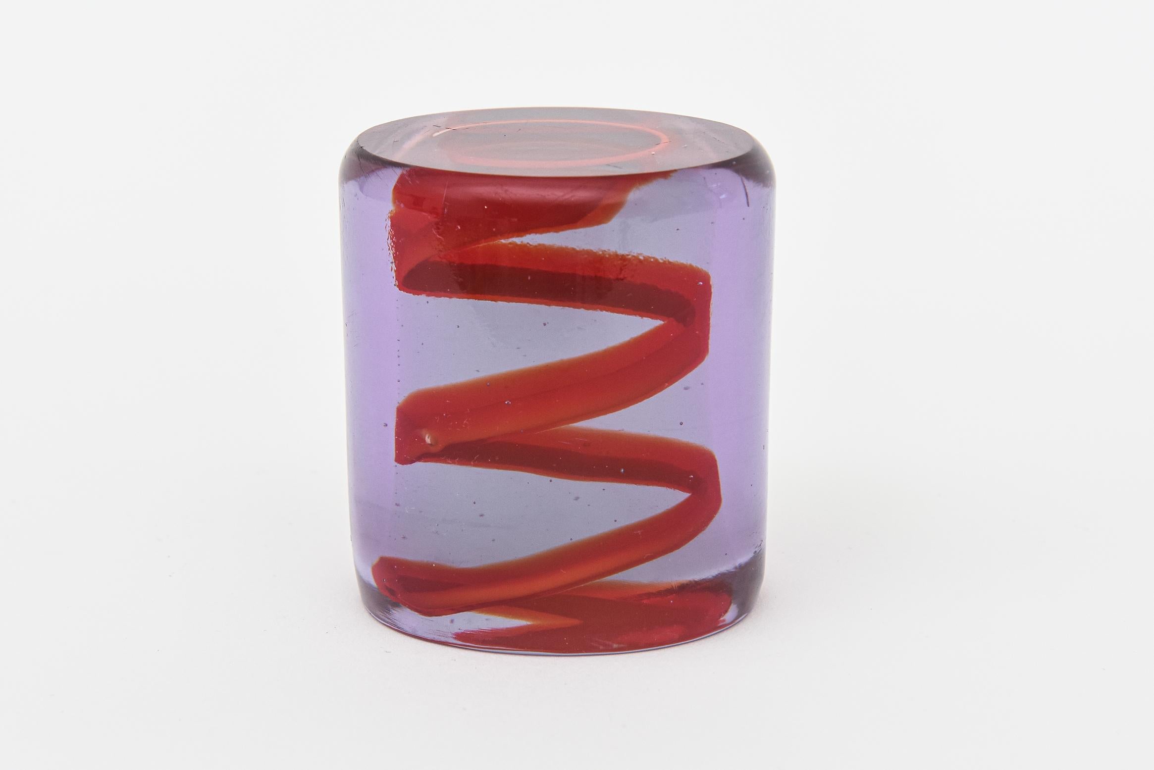 This vintage 1980's glass spiral zig zag paperweight or glass object makes a great desk accessory. The red floating glass zig zag is set of against the purple. Great color combo. It may well be Italian. It is not signed but fabulous.
