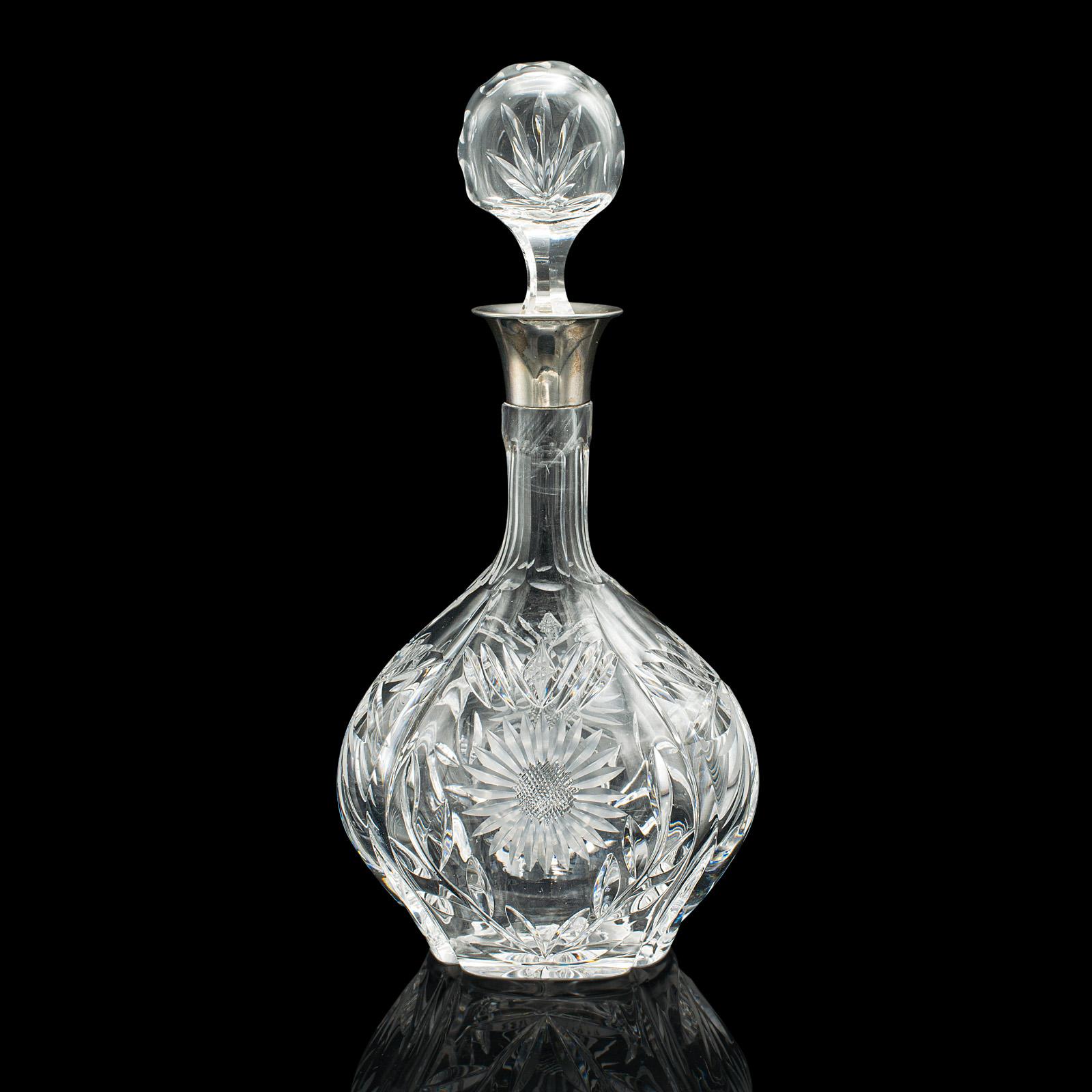 This is a vintage spirit decanter. An English, cut glass and silver collared drinks vessel, dating to the mid 20th century, hallmarked to 1933.

Striking, decorative glass to showcase your favourite spirit
Displaying a desirable aged patina and in