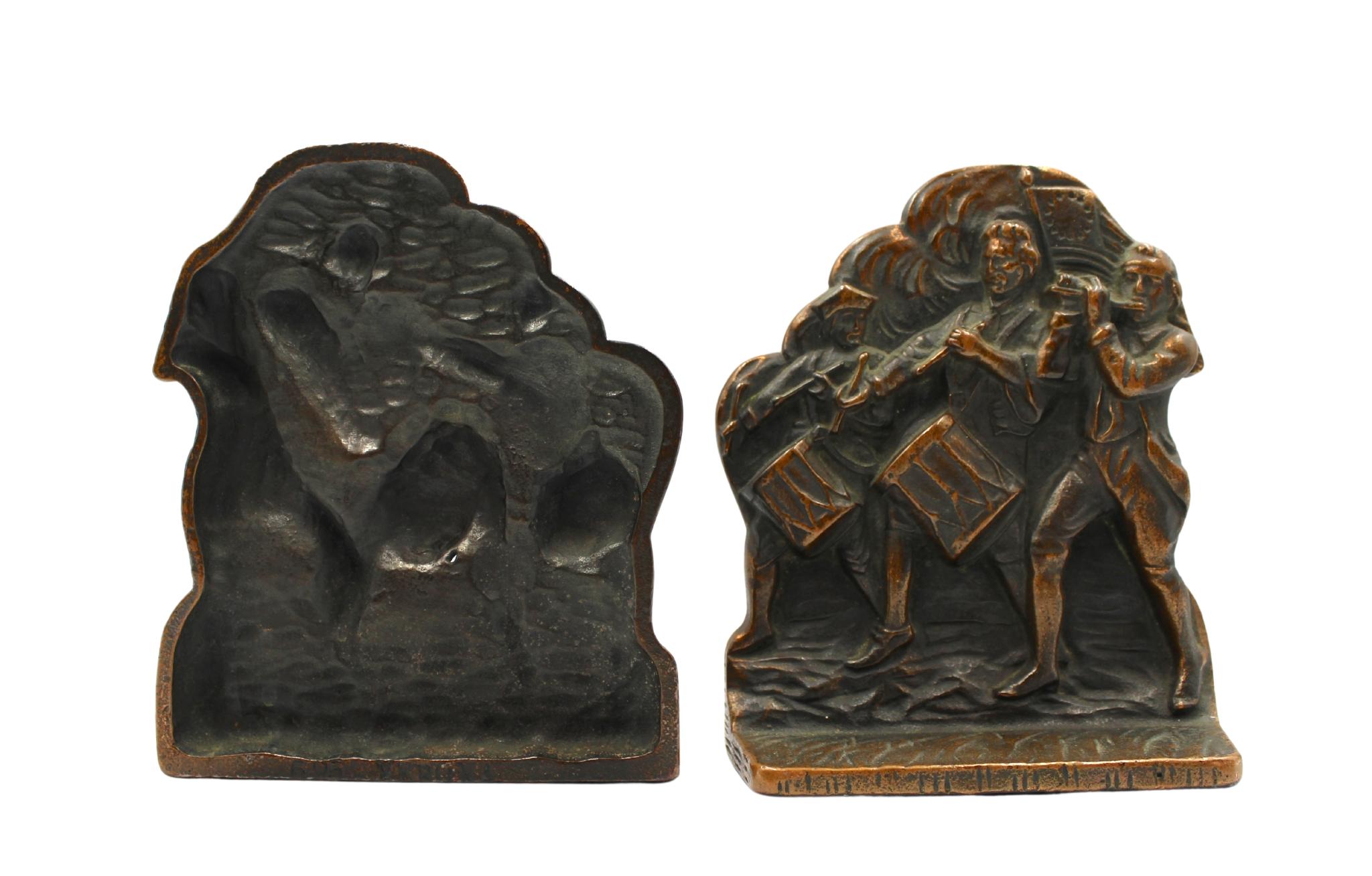 Offered is a set of vintage brass Revolutionary War soldiers bookends. Each bookend depicts a fife player and two drummers, marching in step together across a grassy field. In the background, a large 13-star medallion flag waves in the air. These